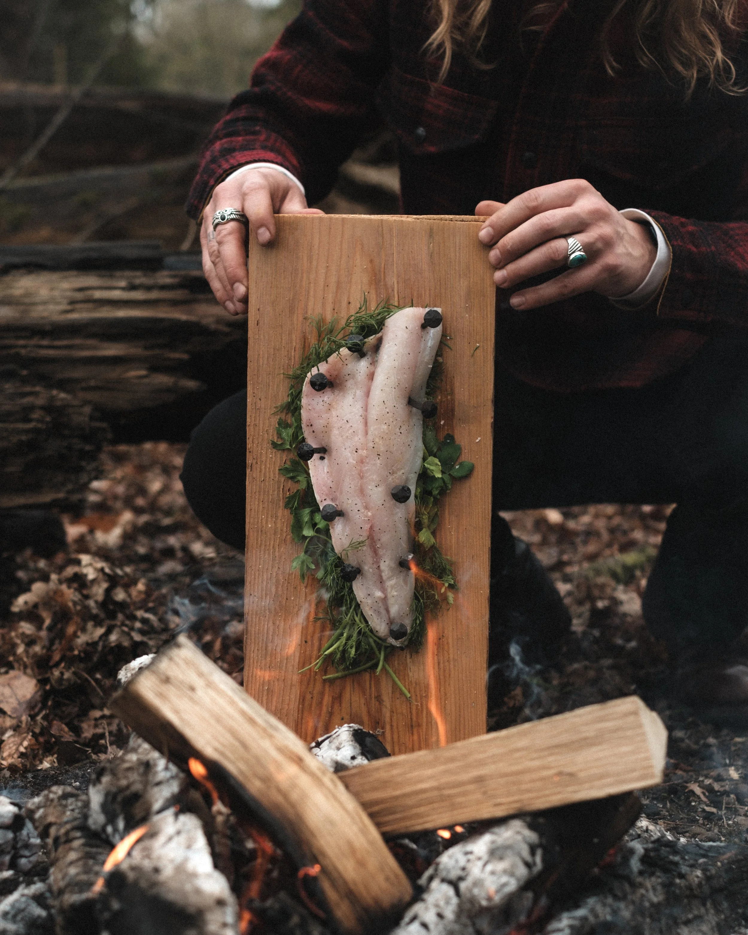 Cedar plank cooking fish over fire