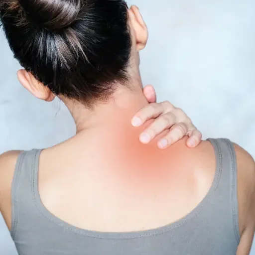 Woman holding neck in pain, representing treatment options from a Guthrie pain management doctor.
