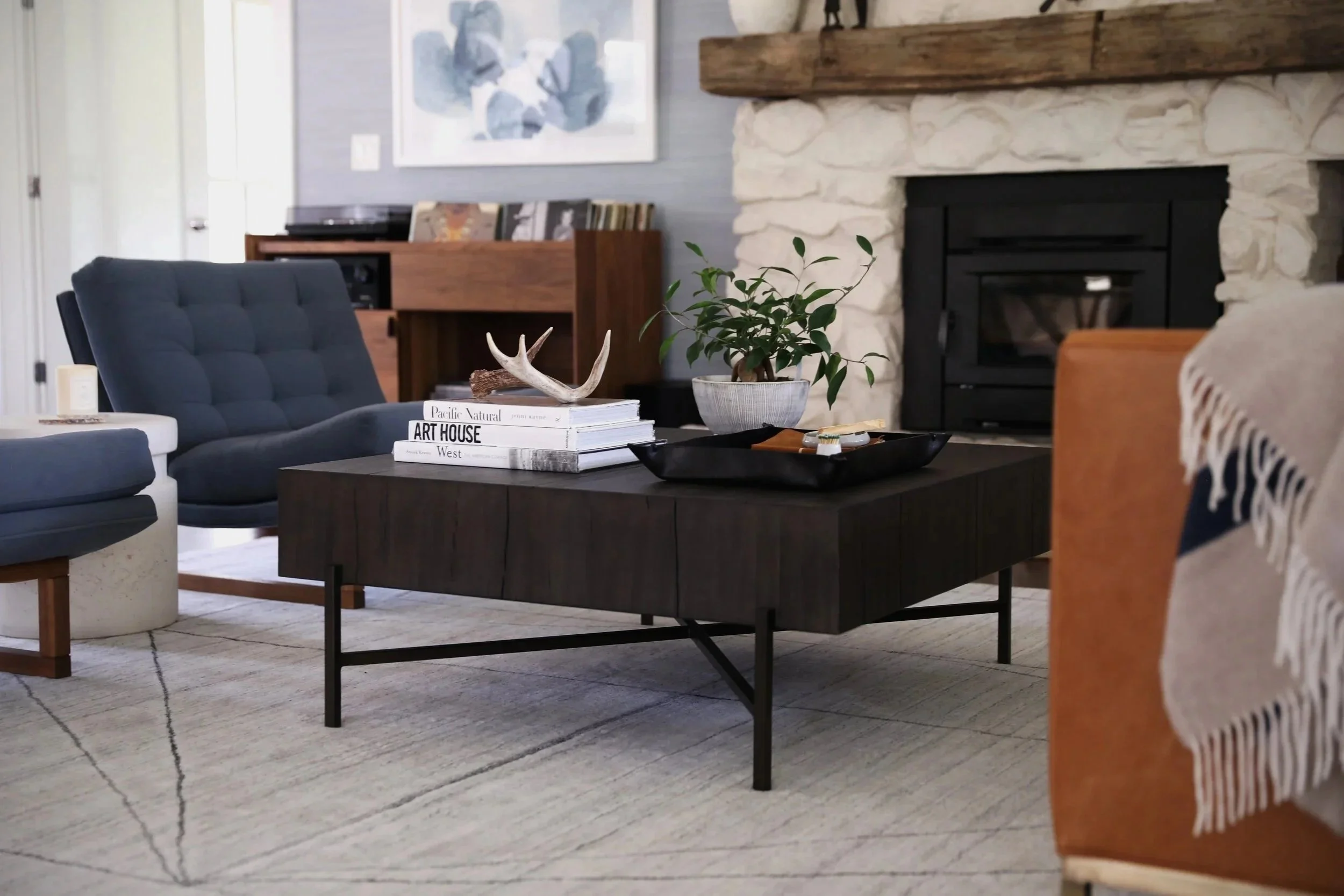 Layered living room with stone fireplace and walnut coffee table designed by The Stage in Madison, Wisconsin