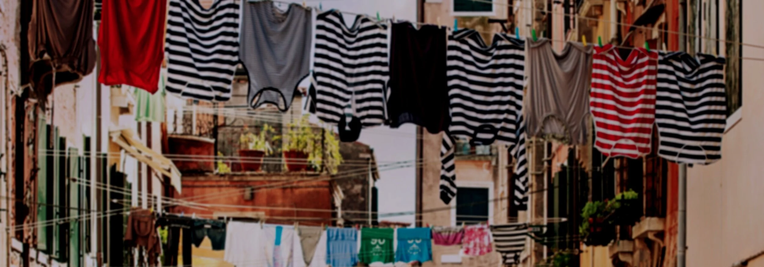 Canva+-+Striped+Shirt+Hanging+on+Gray+Wire+Between+Beige+Painted+Wall+Building+during+Daytime.jpg
