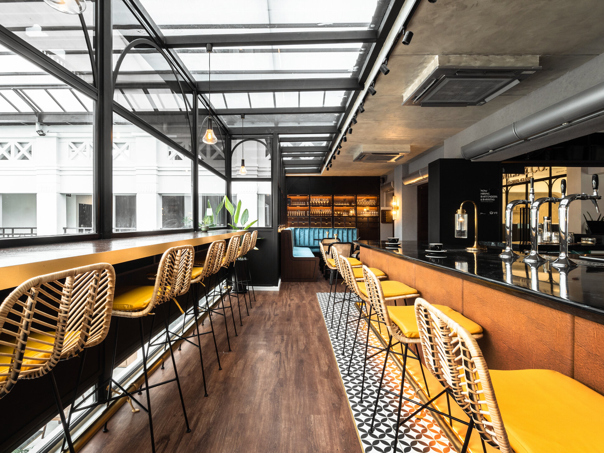  The language of the space is informed by its unique function as both a cafe and a bar lounge - as can be seen by the juxtaposition of the vintage-inspired liquor cabinets and rattan furniture pieces. 