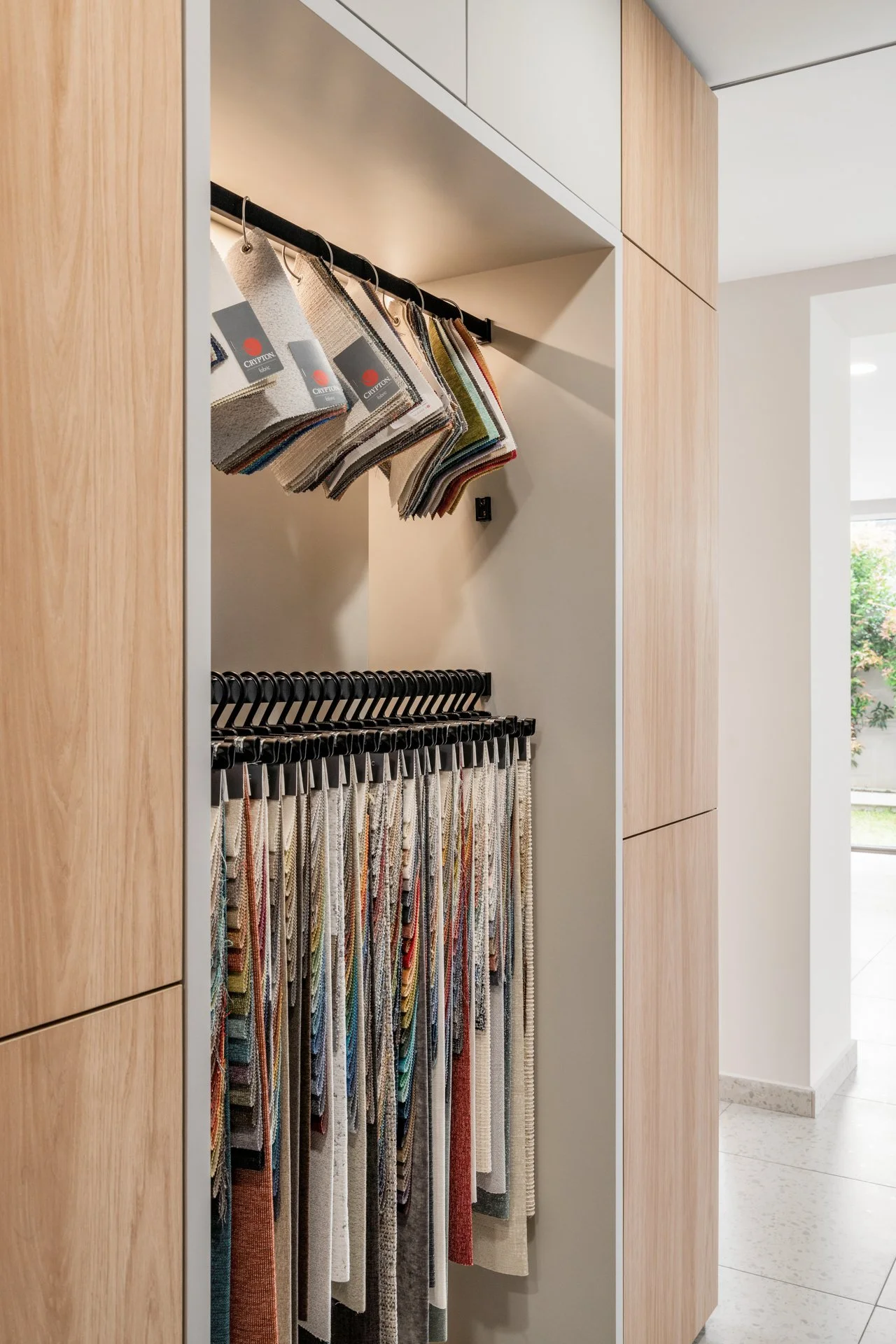  Fabric swatches in myriad colours hang from the wardrobe rails, in place of shirts and blouses. 