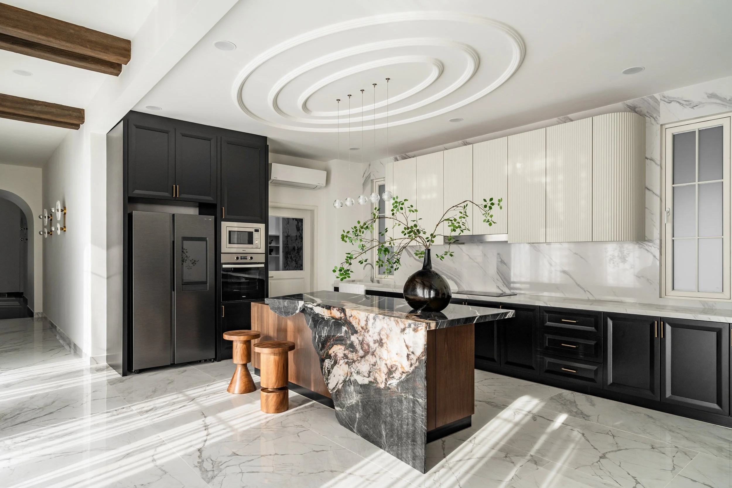  Here at IDent-3’s Arch House, late afternoon sun weaves intricate patterns of shadow across the white marble floors; and as twilight descends, the quartzite marble counter becomes a luminous centerpiece, bathed in a gentle backlit glow. 
