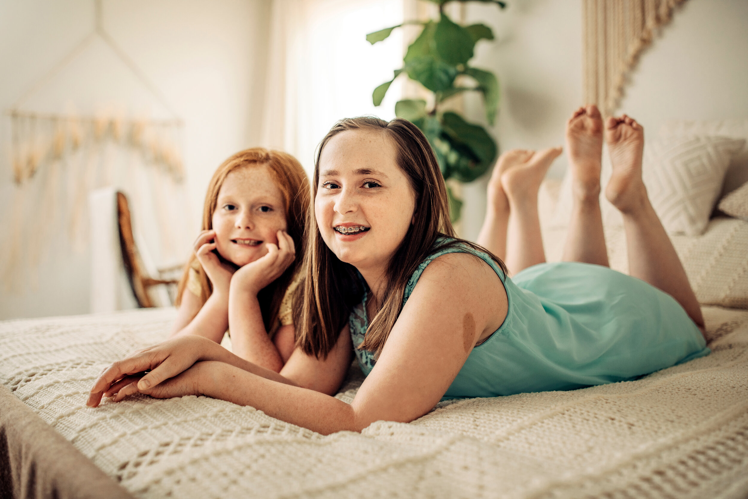 Montgomery Alabama Photographer - two sisters lay on their stomachs and look at the camera in Pike Road, Alabama