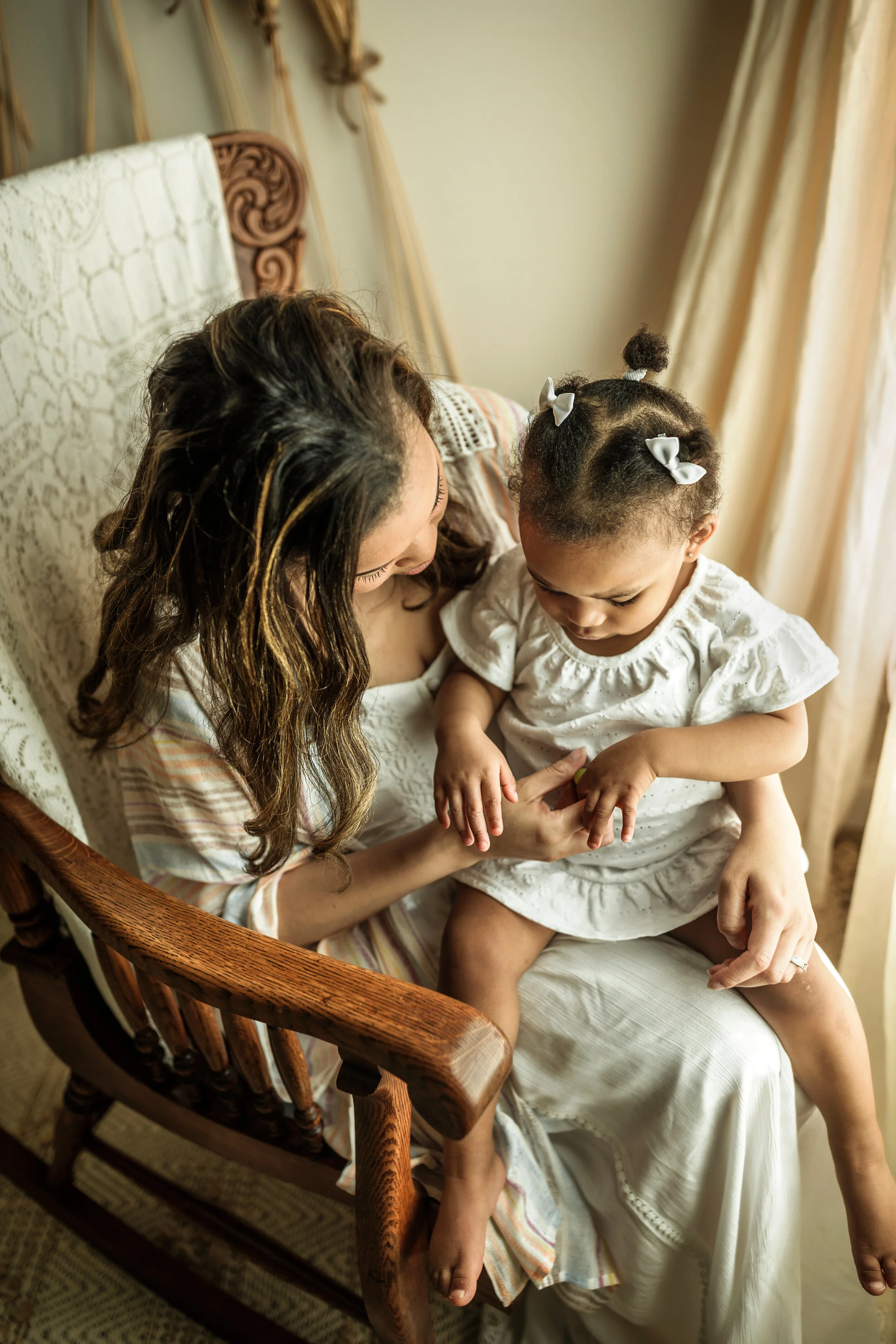 Montgomery Alabama Photographer - A mother looks at her young daughter as they sit in a rocking chair in Pike Road, Alabama