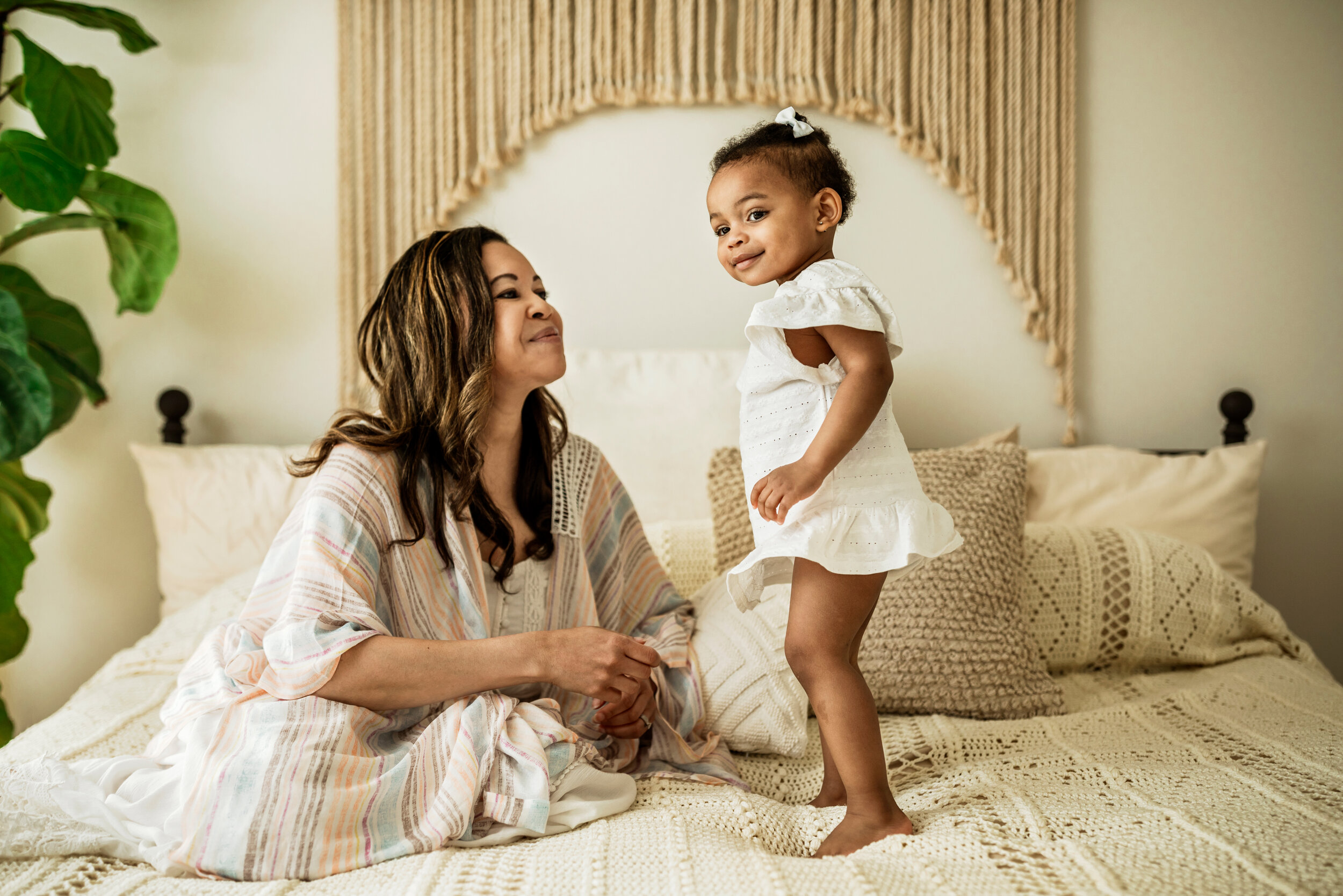 Montgomery Alabama Photographer - A mother looks up at her daughter, who stands on a bed in Pike Road, Alabama