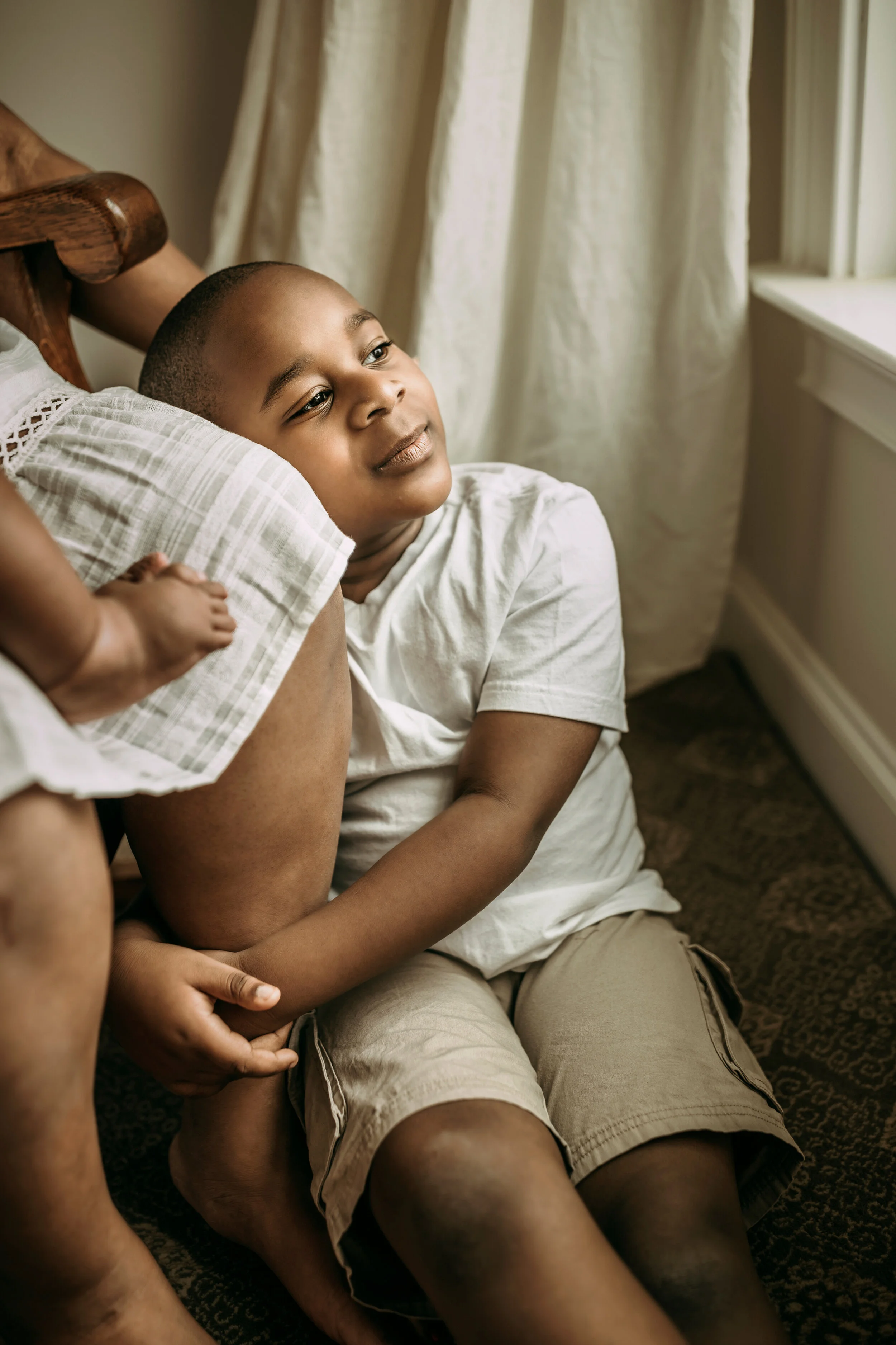 Montgomery Alabama Photographer - A little boy hugs his mother’s leg as she sits in a rocking chair in Pike Road, Alabama