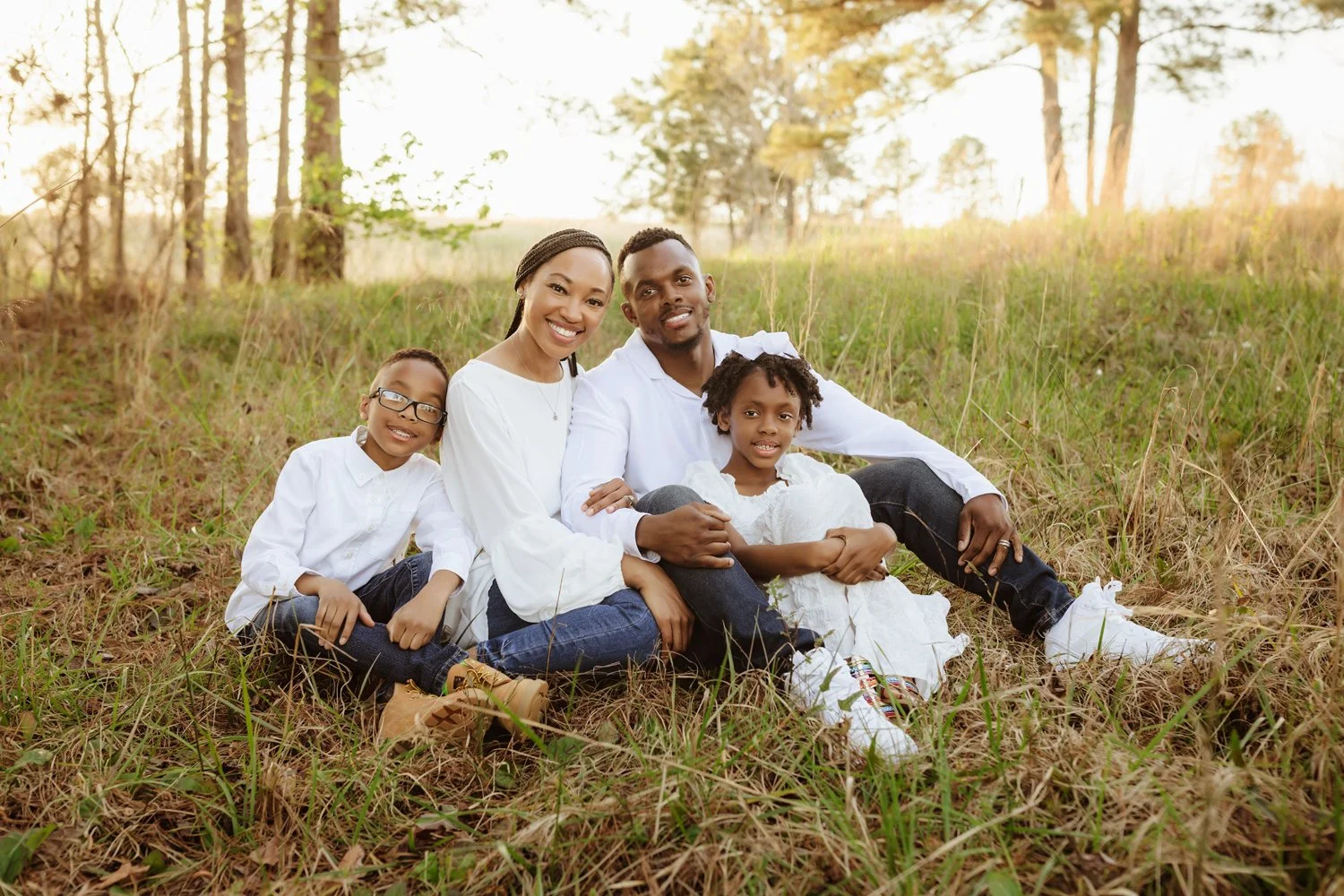 A mother and father sit with their two children near Lake Martin, Alabama during a photo session with Montgomery Photographer m.Clemm photography