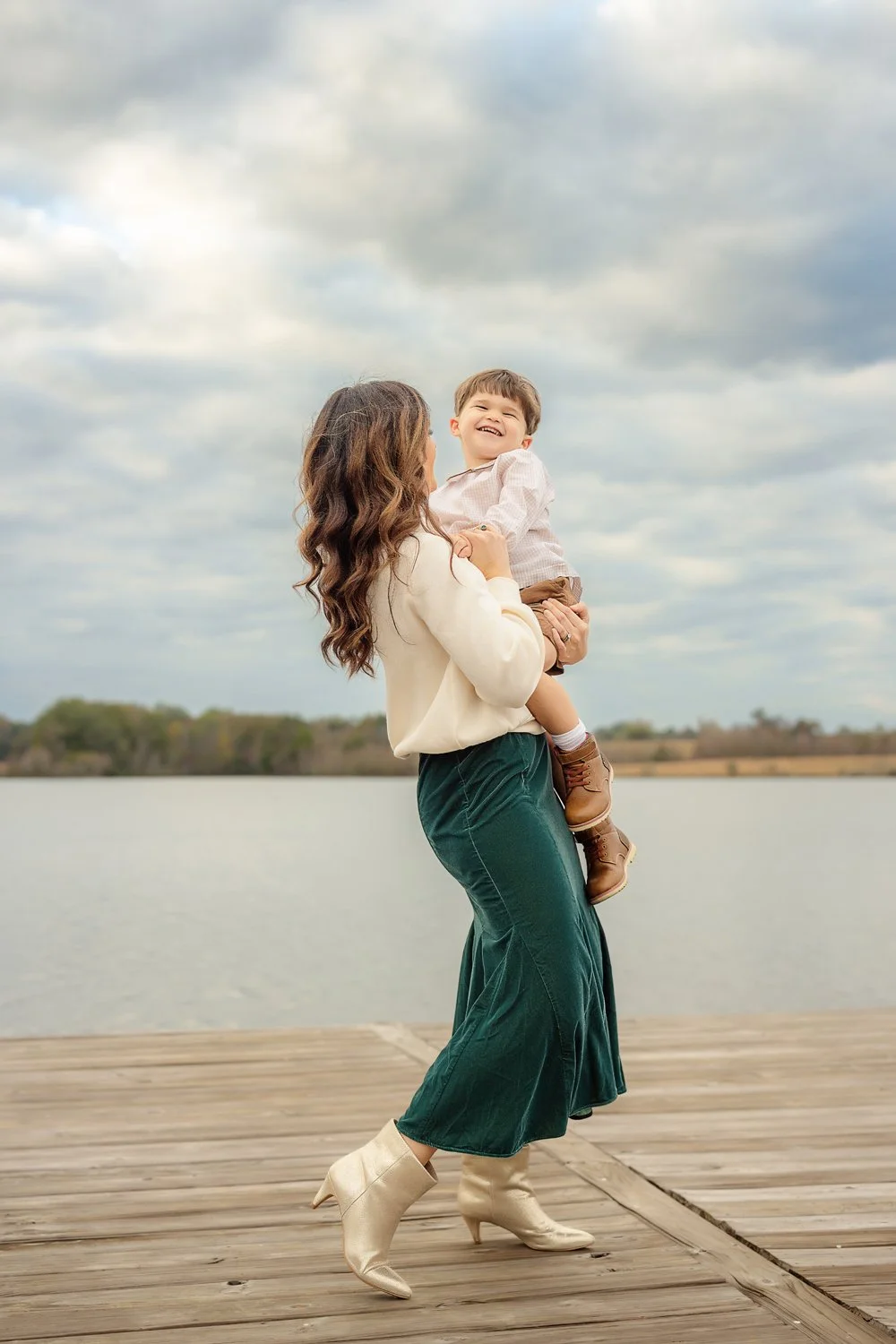 A woman holds her young son and sways on a dock in Pike Road, Alabama during a photo session with m.Clemm photography
