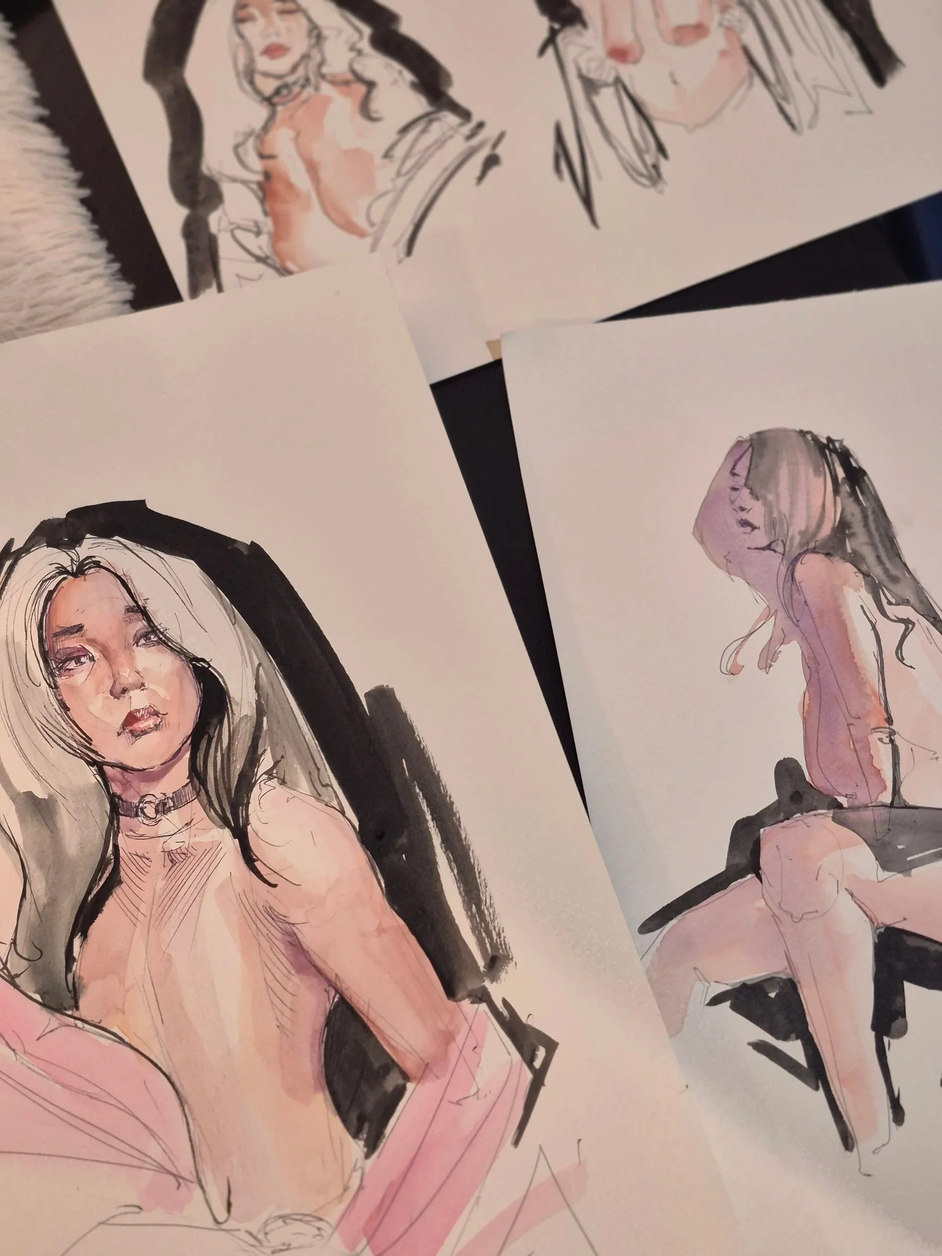 Collection of watercolor nude drawings of women on white paper.