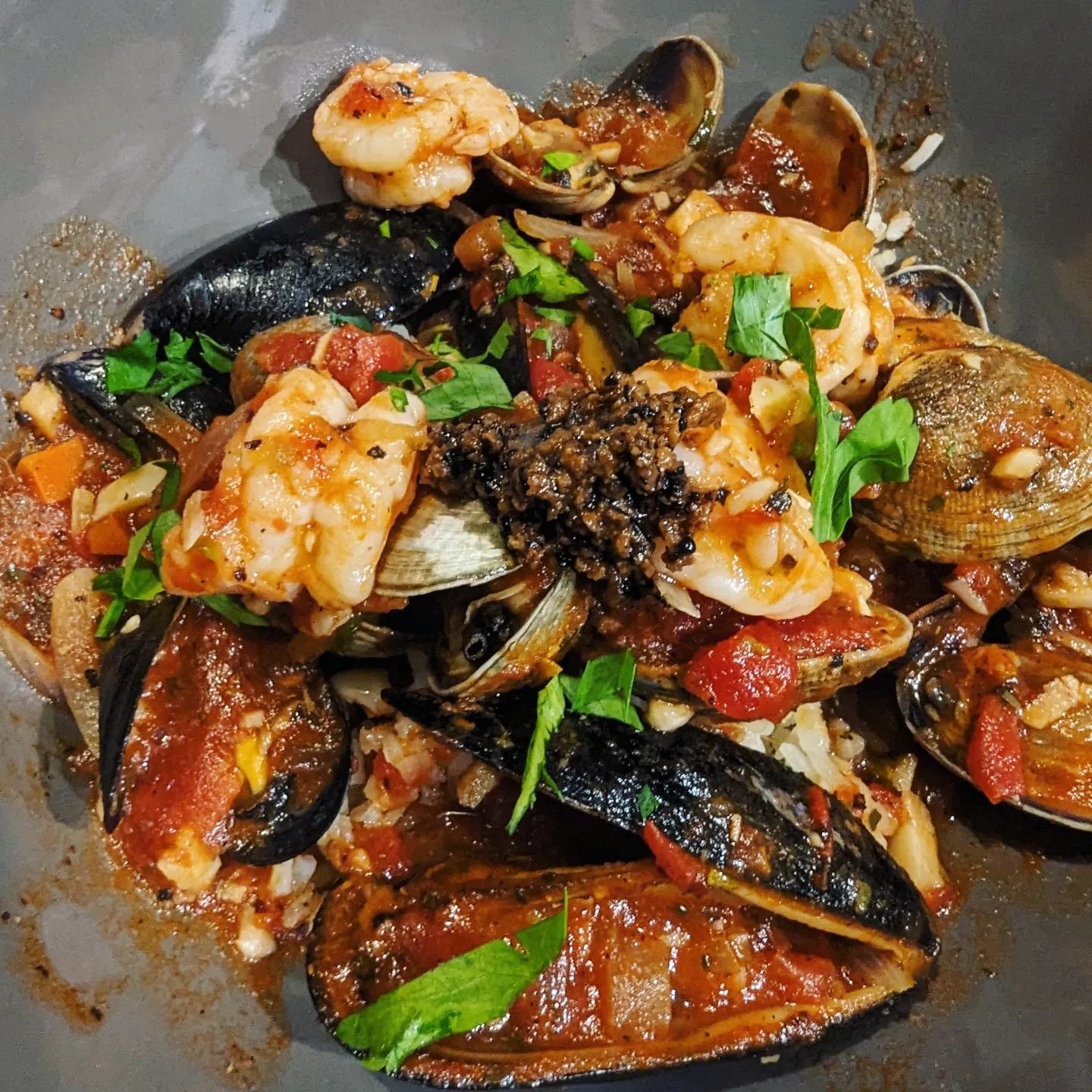 Mussels and clams from @hamahamaoysters, with shrimp, in a garlic, shallot and spicy tomato  white wine sauce. Over basil arborio rice, and finished with minced black truffle and fresh parsley.  For the recipe, pick my brain, I don't do recipes. 🤣 
