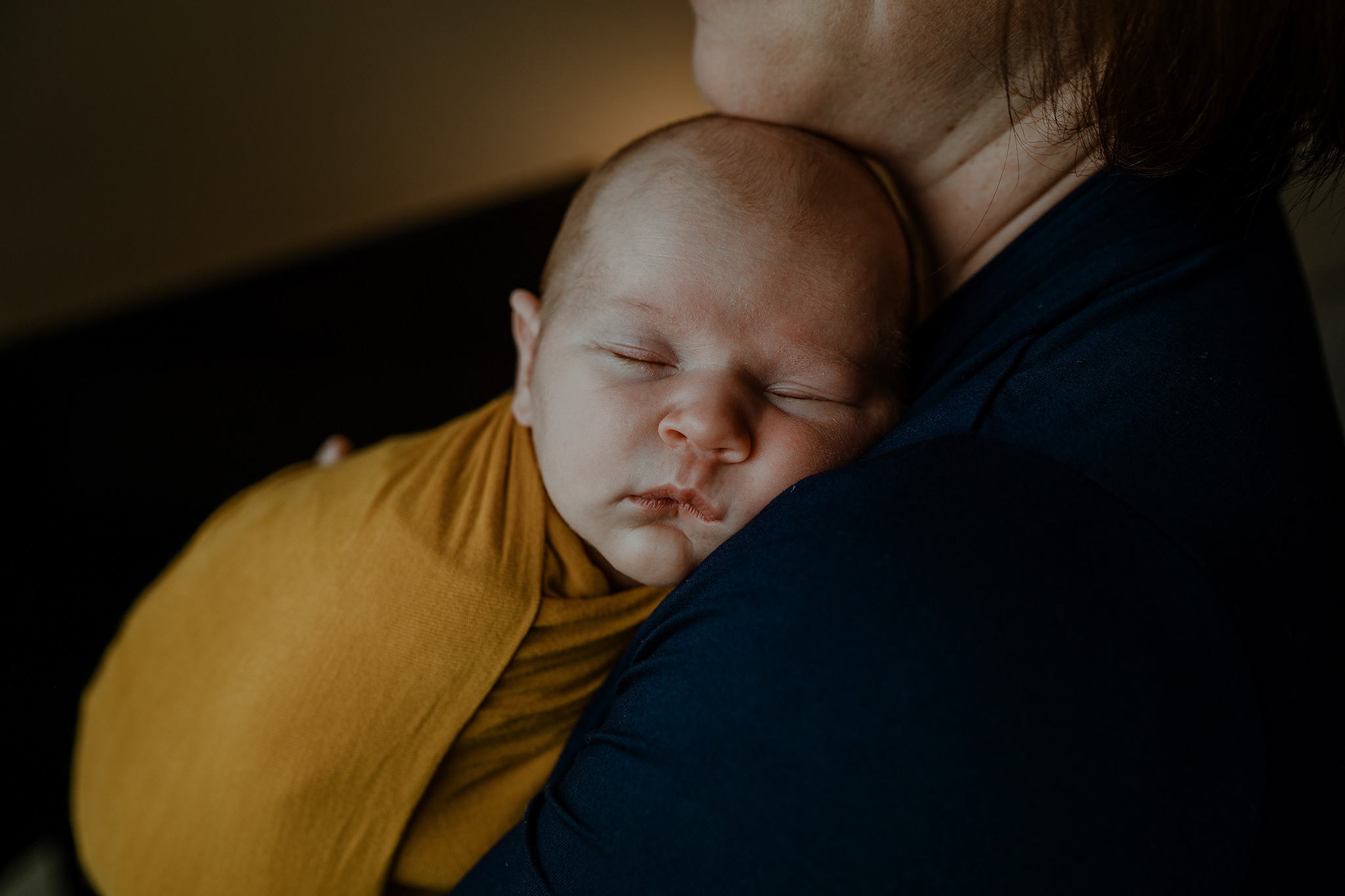 newborn baby girl in mothers arms yellow wrap Newborn Photographer Belfast