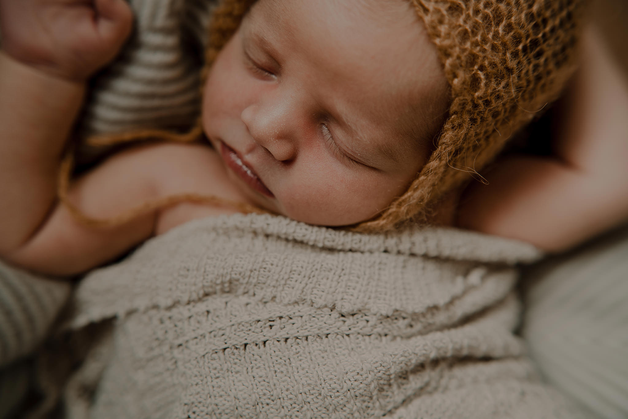 mustard bonnet and cream textured blanket in home newborn photographer Belfast