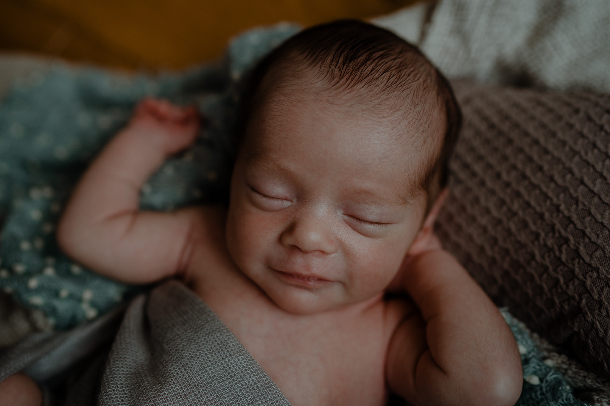 smiling newborn boy in home newborn session creative newborn photographer Belfast