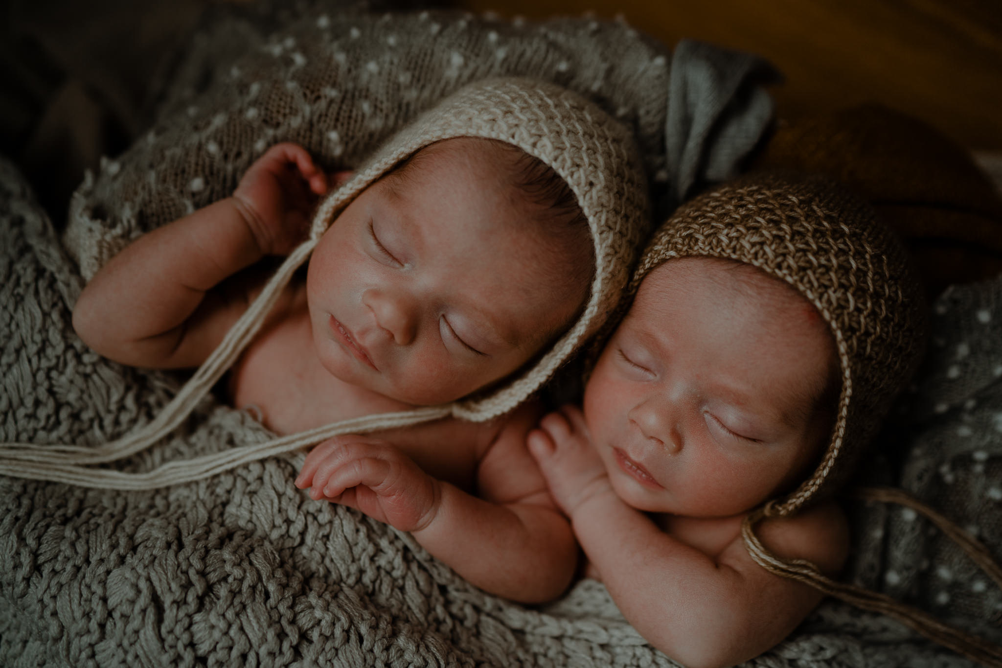 newborn twins in bonnets cream and stone creative newborn photographer Belfast