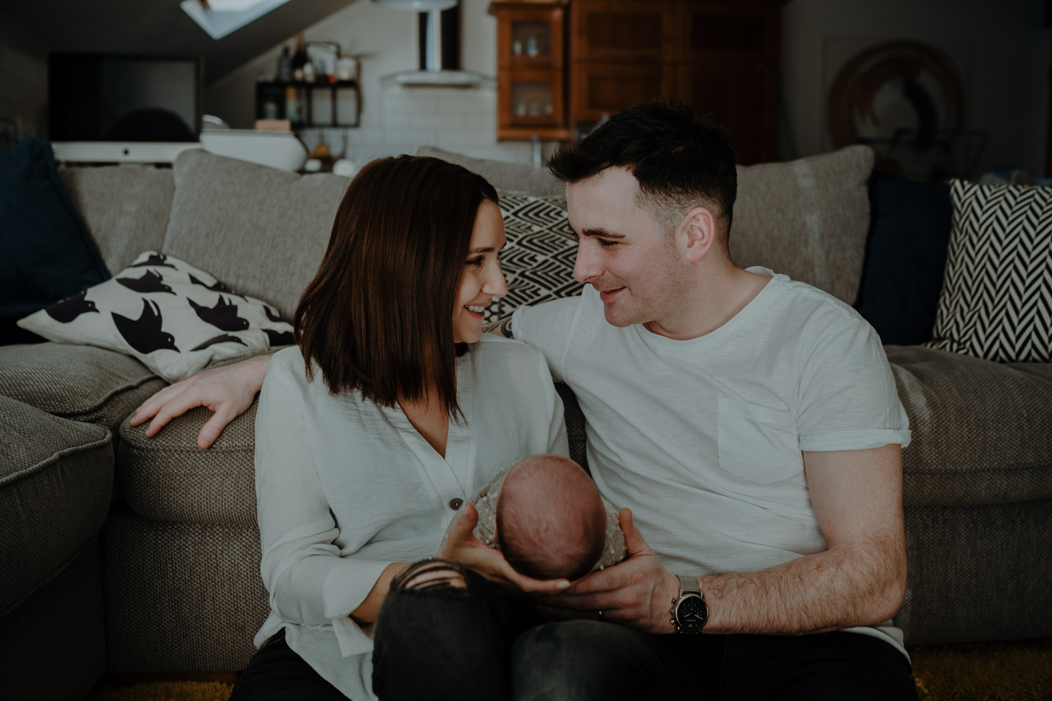 baby photographer Belfast in home new parents newborn in lap on sofa