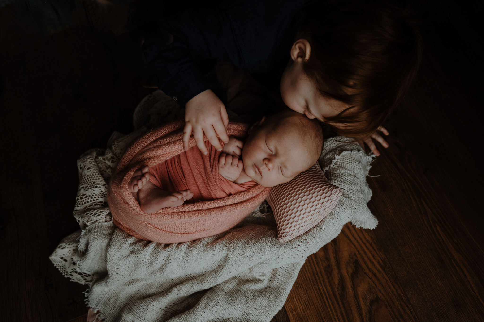 toddler-kisses-newborn-baby-sister-belfast-photograher