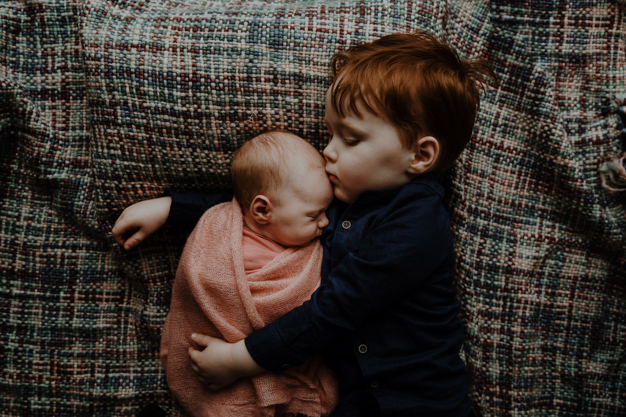 big brother kisses newborn sister artistic newborn photographer belfast