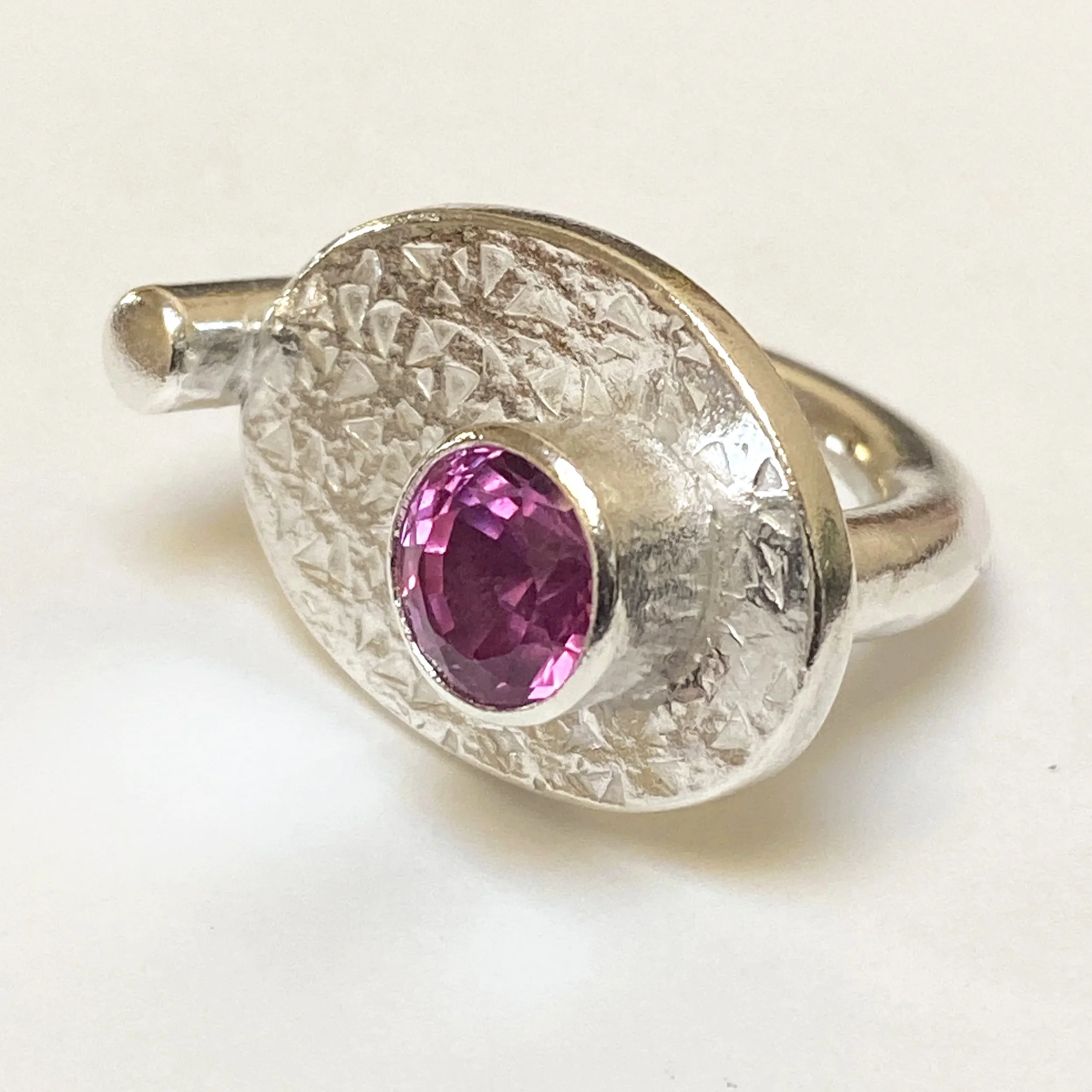 Silver and laboratory grown pink gem