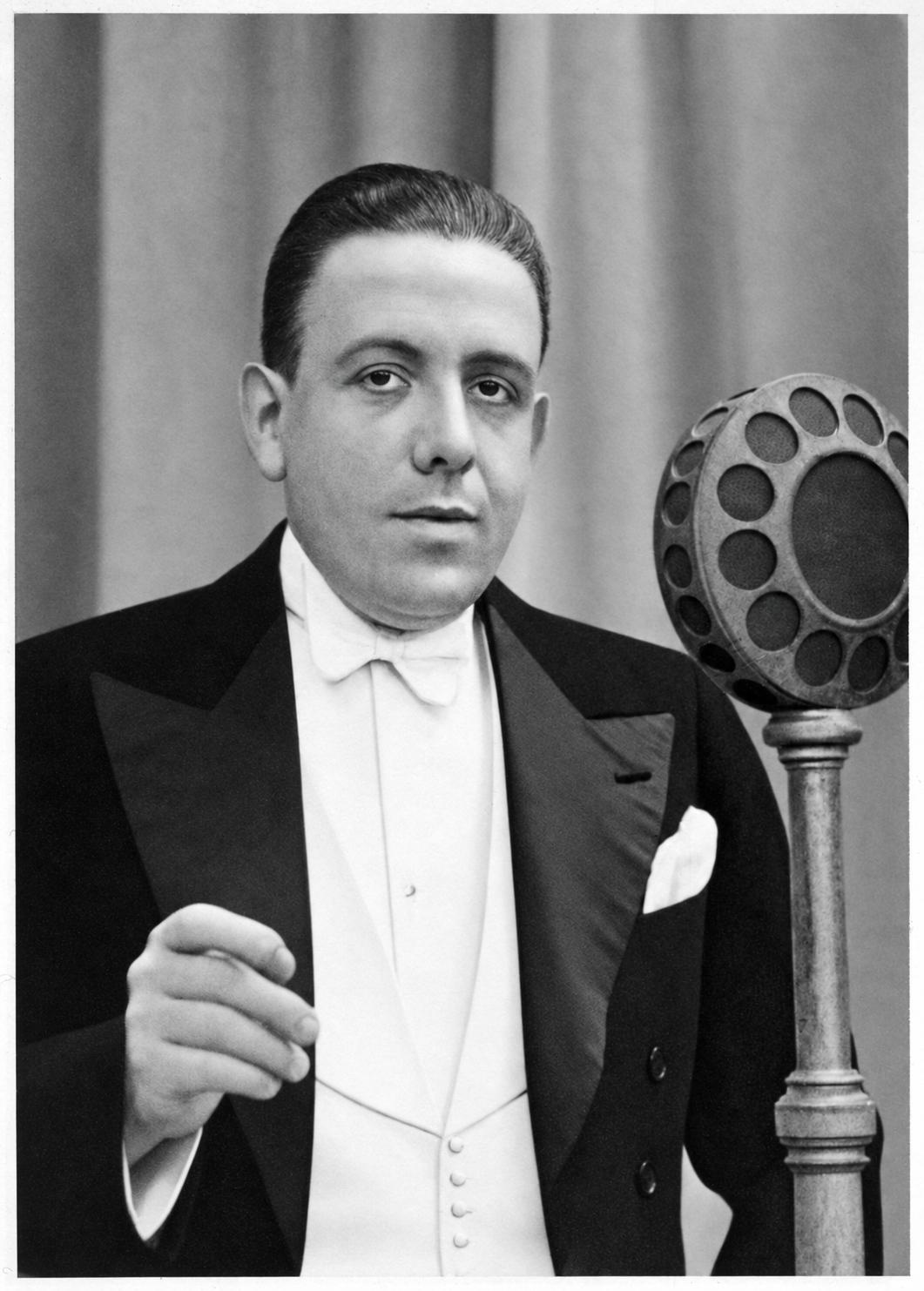 Francis Poulenc standing beside a period microphone