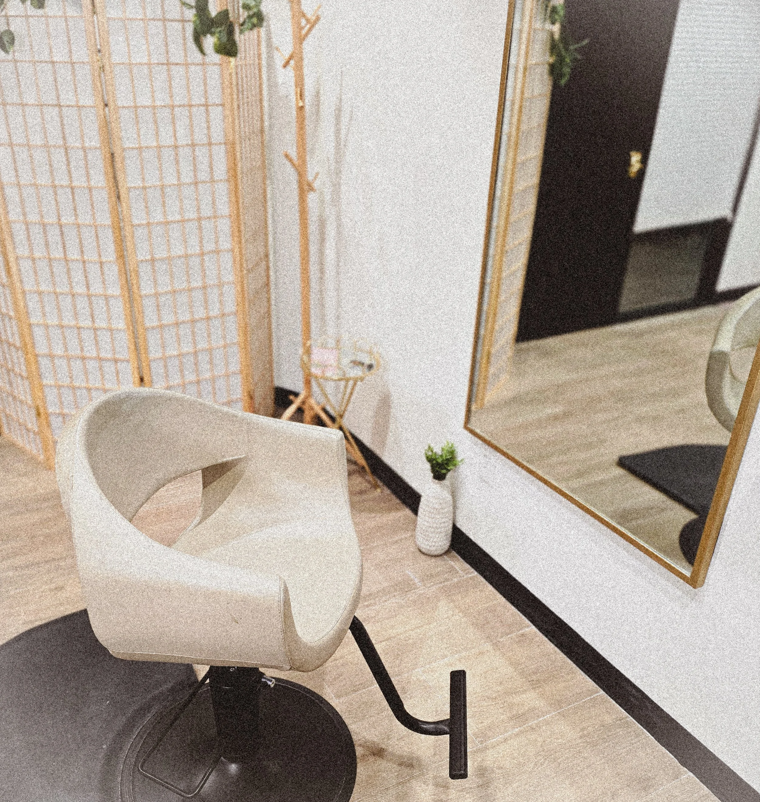 Beige Hair Salon Chair in front of gold mirror inside a private salon.