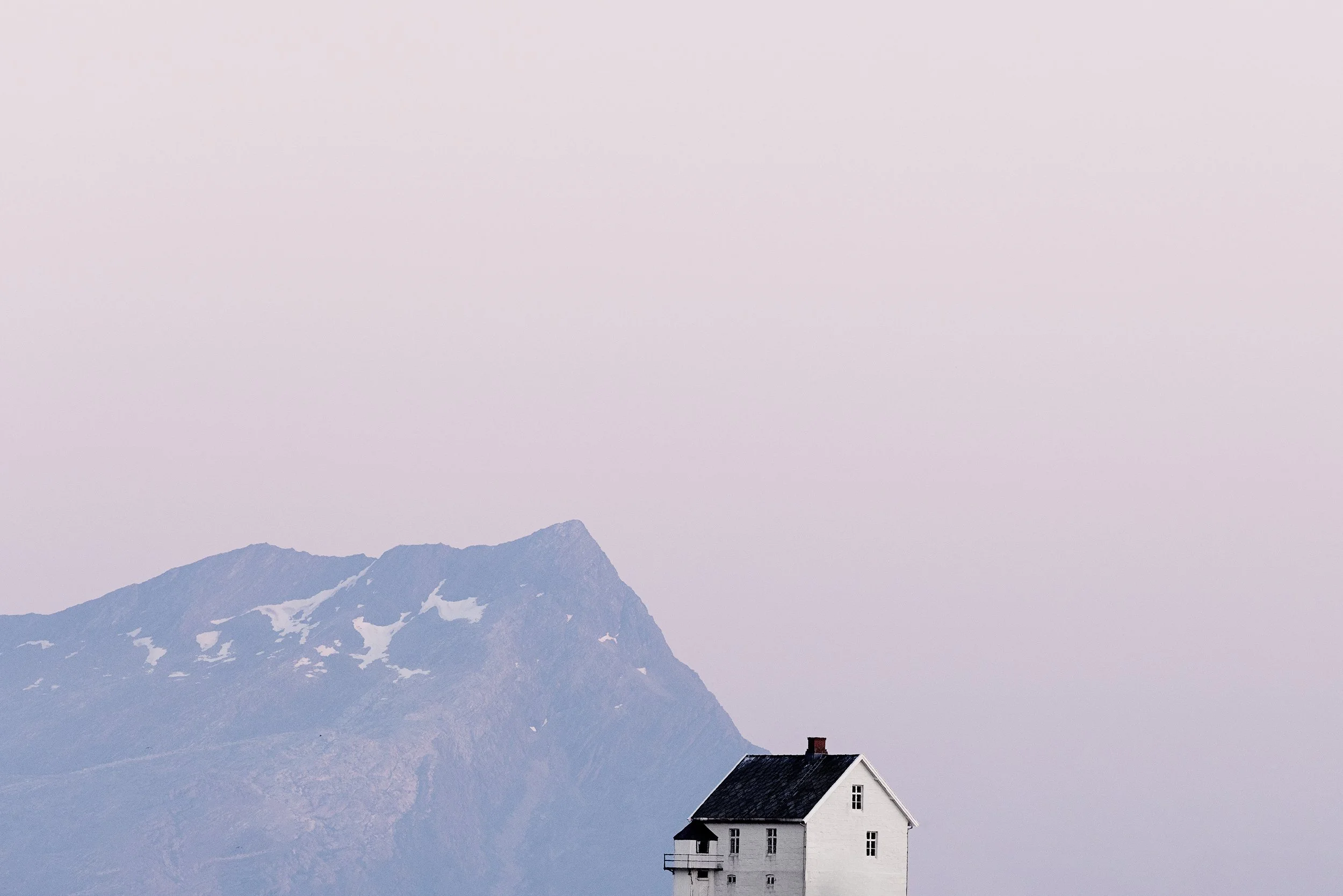 Nyholmen, Norway - During the midnight sun, the low-angle sunlight passes through more atmosphere, scattering blue light and leaving strong reds and soft pastels. In this long Arctic twilight, even a small house becomes an anchor under a sky that nev