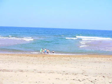 Quiescent areas with only small breaking waves can look very inviting for swimming and bathing, but these holes in the bar are the place where rip currents form (photo by David Elder on the Outer Banks of North Carolina).