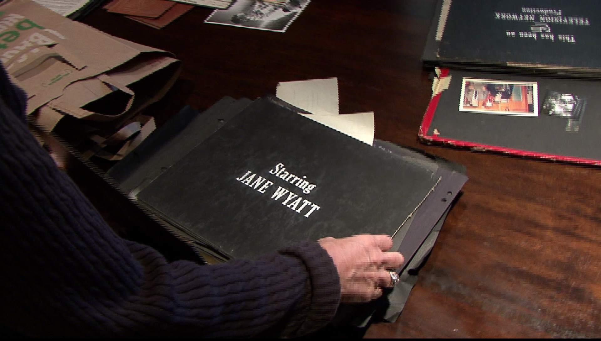 Looking through the family scrapbook in TV Family.