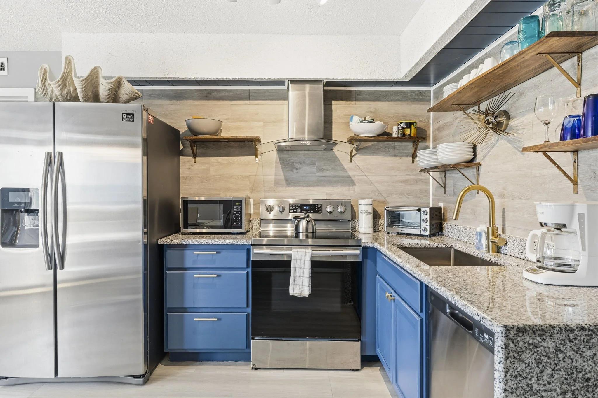 From the striking blue cabinetry and granite countertops to the stainless steel appliances and designer finishes, this fully equipped kitchen was thoughtfully designed for both function and style.