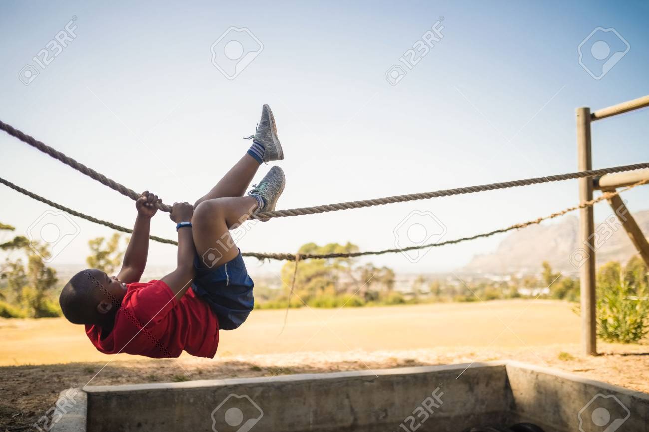 79252177-determined-boy-crossing-the-rope-during-obstacle-course-in-boot-camp.jpg