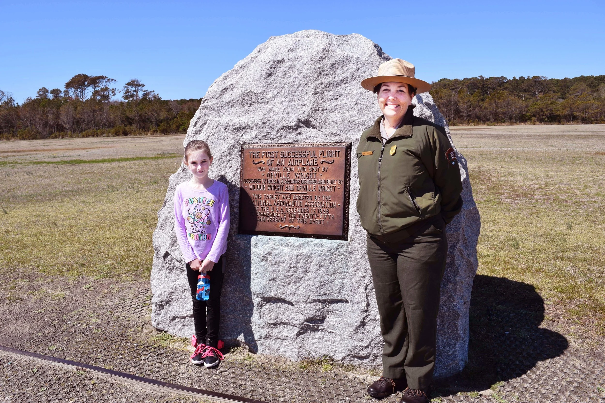 Molly Lam, 10, left, of Abilene, Texas poses with park ranger Amiee Ginnever at the lift-off monument at Wright Brothers National Memorial.