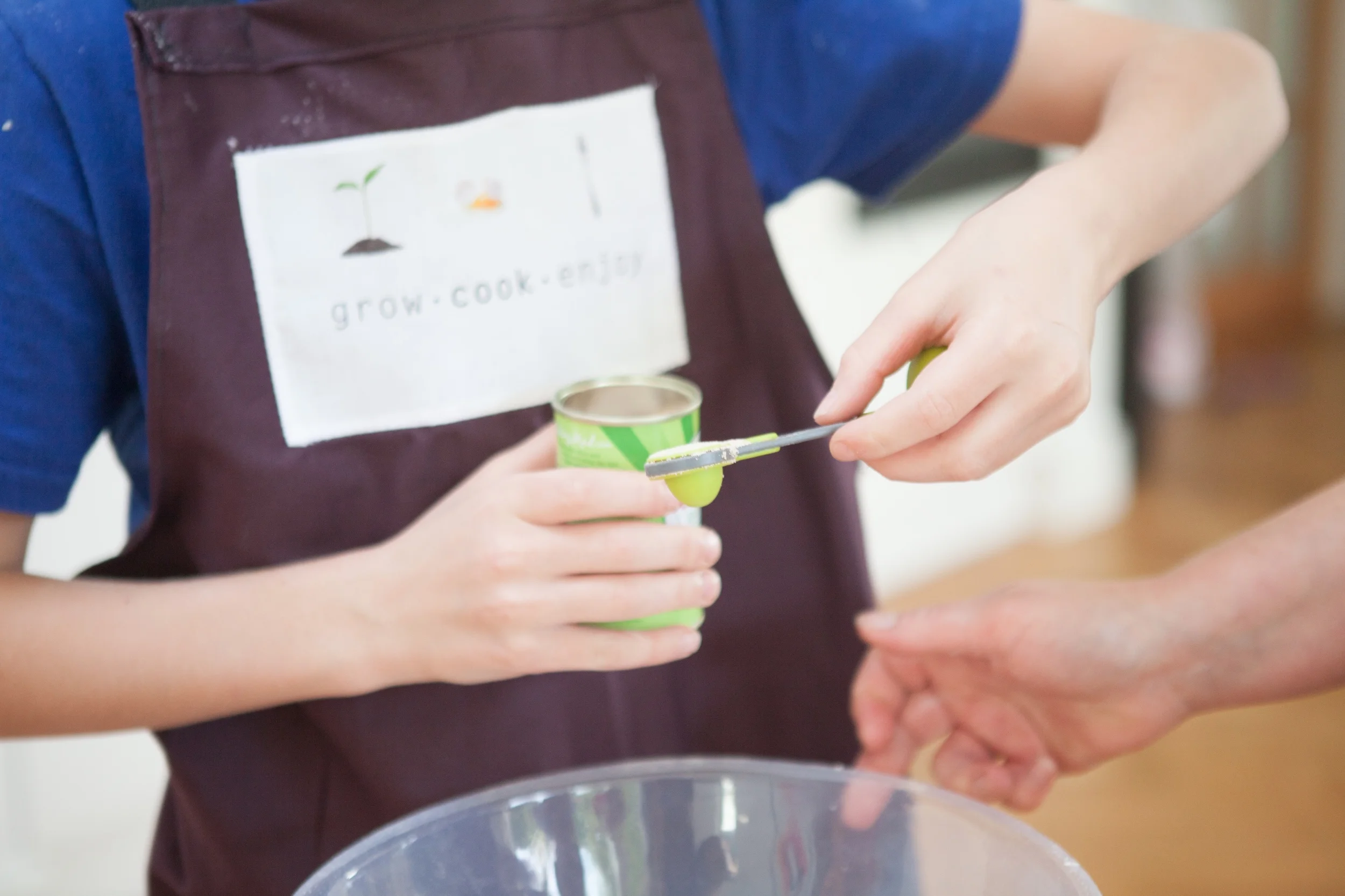 Child measuring yeast to add to a recipe