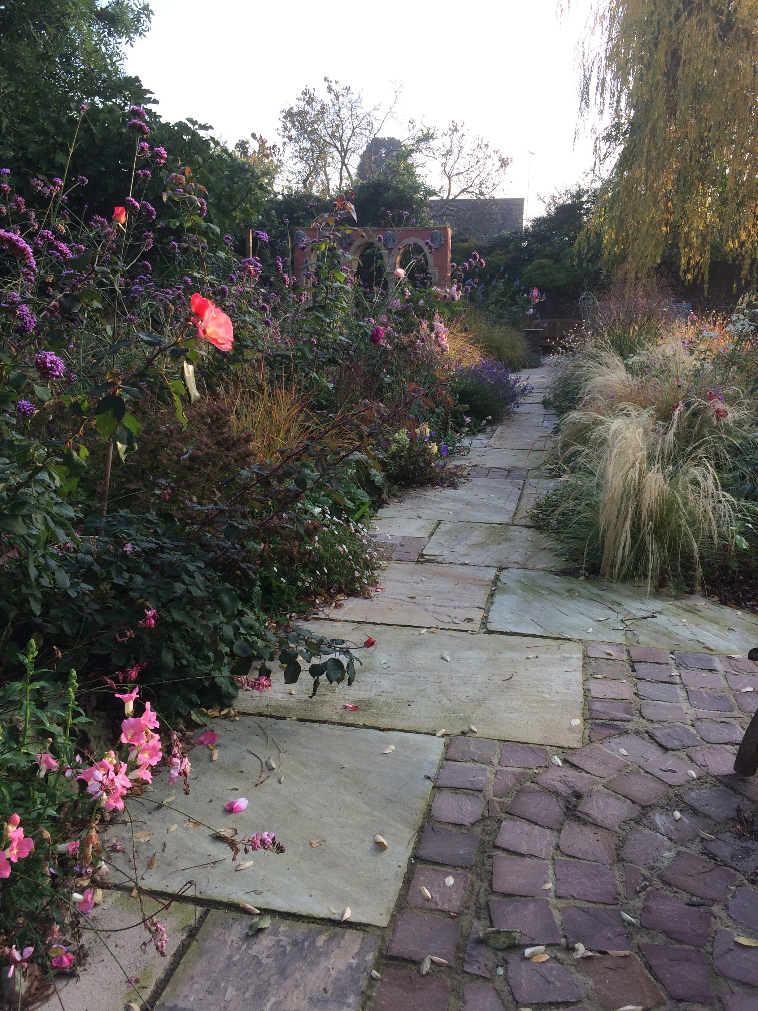 Sandstone Paving with contrasting Sandstone Sett detailing draws the eye down through the planting.