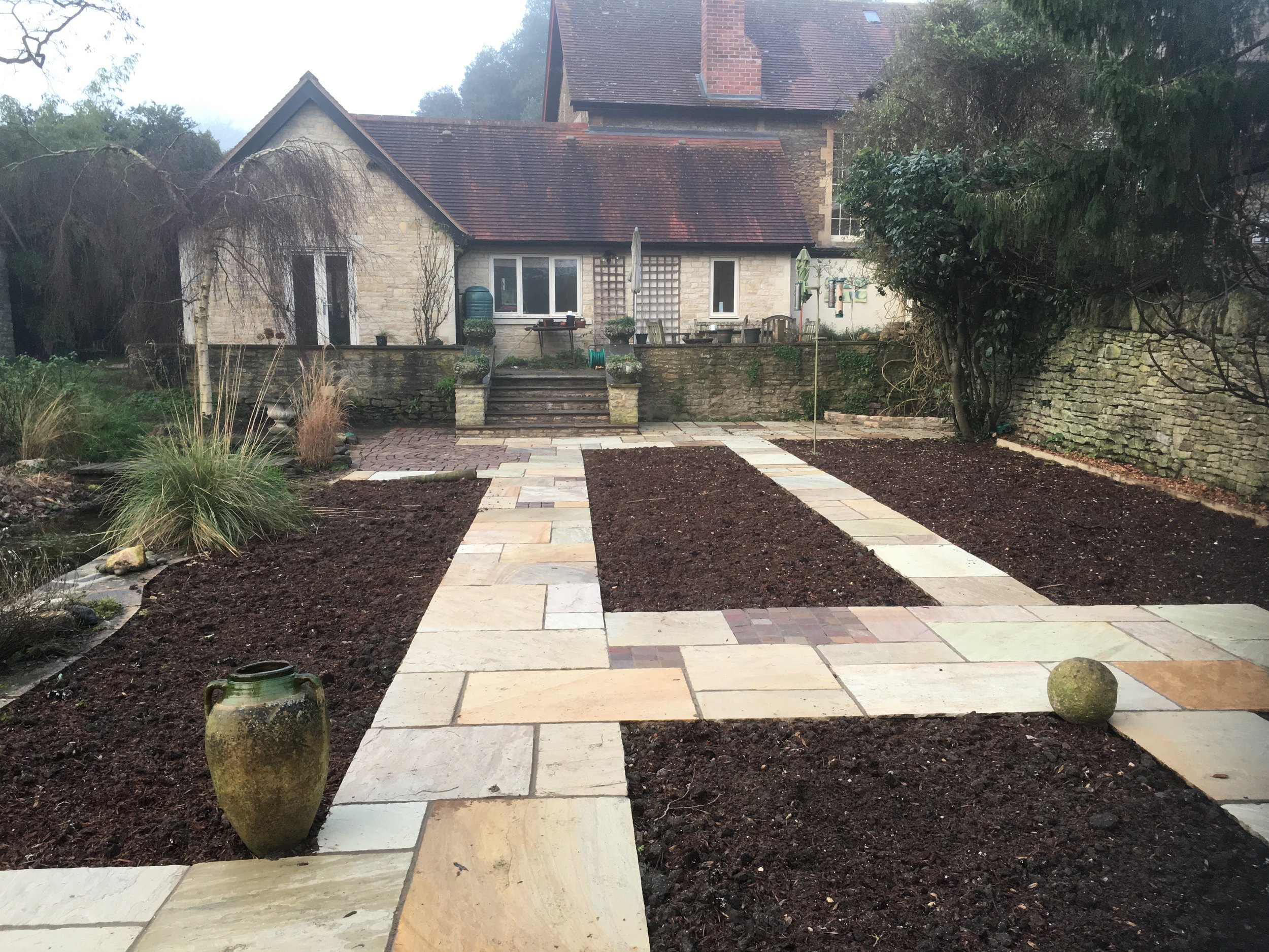 Following the initial landscaping work a series of formal rectangular beds were framed with natural sandstone paving.