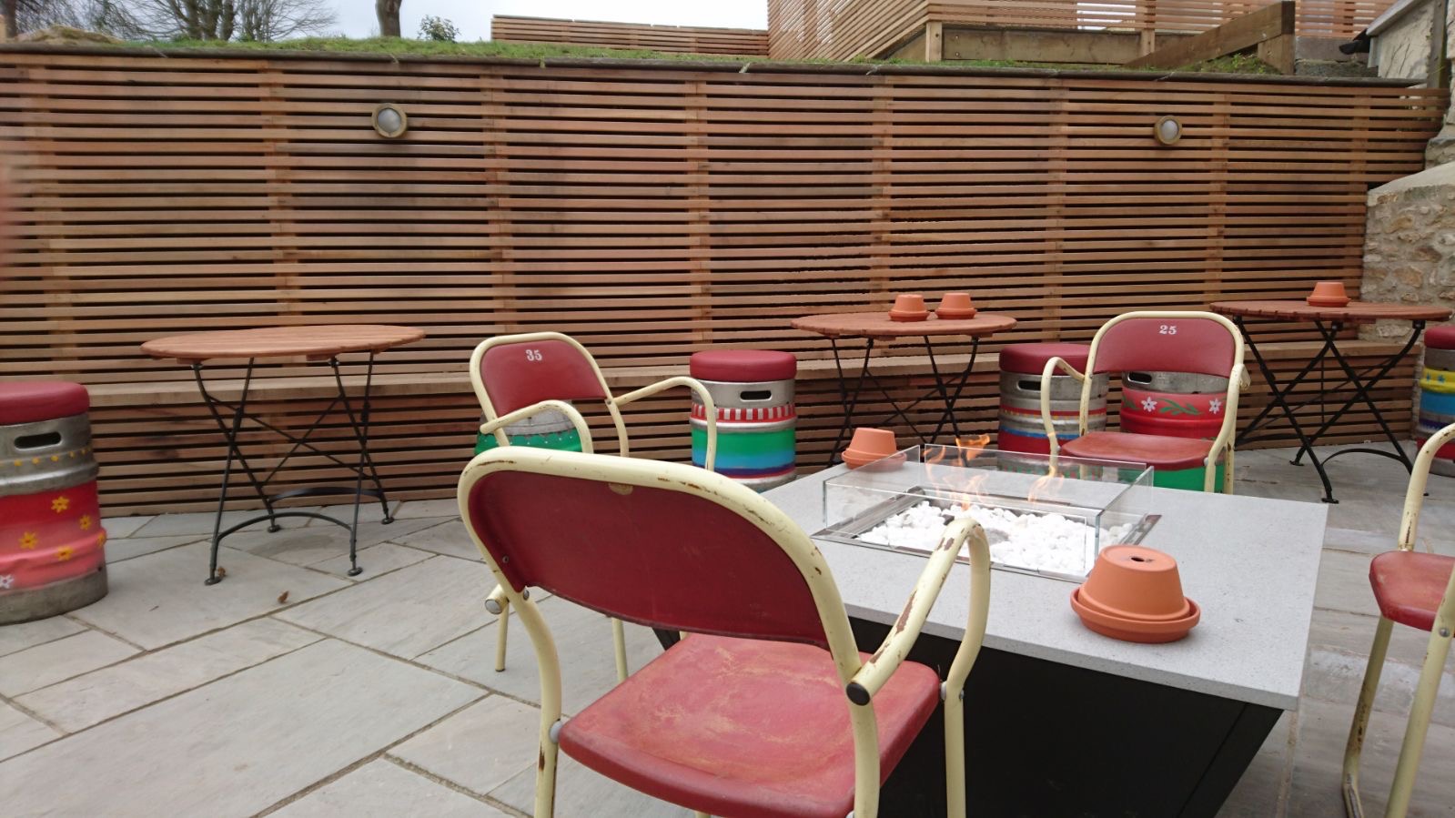 Fire pit forms the central feature in the entrance courtyard. Sandstone paving with cedar clad walls provide contrast and style.