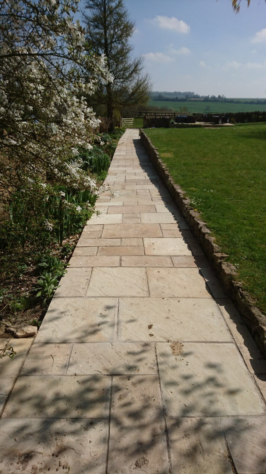 Running alongside the raised croquet lawn the pathway leads out into the paddock beyond.