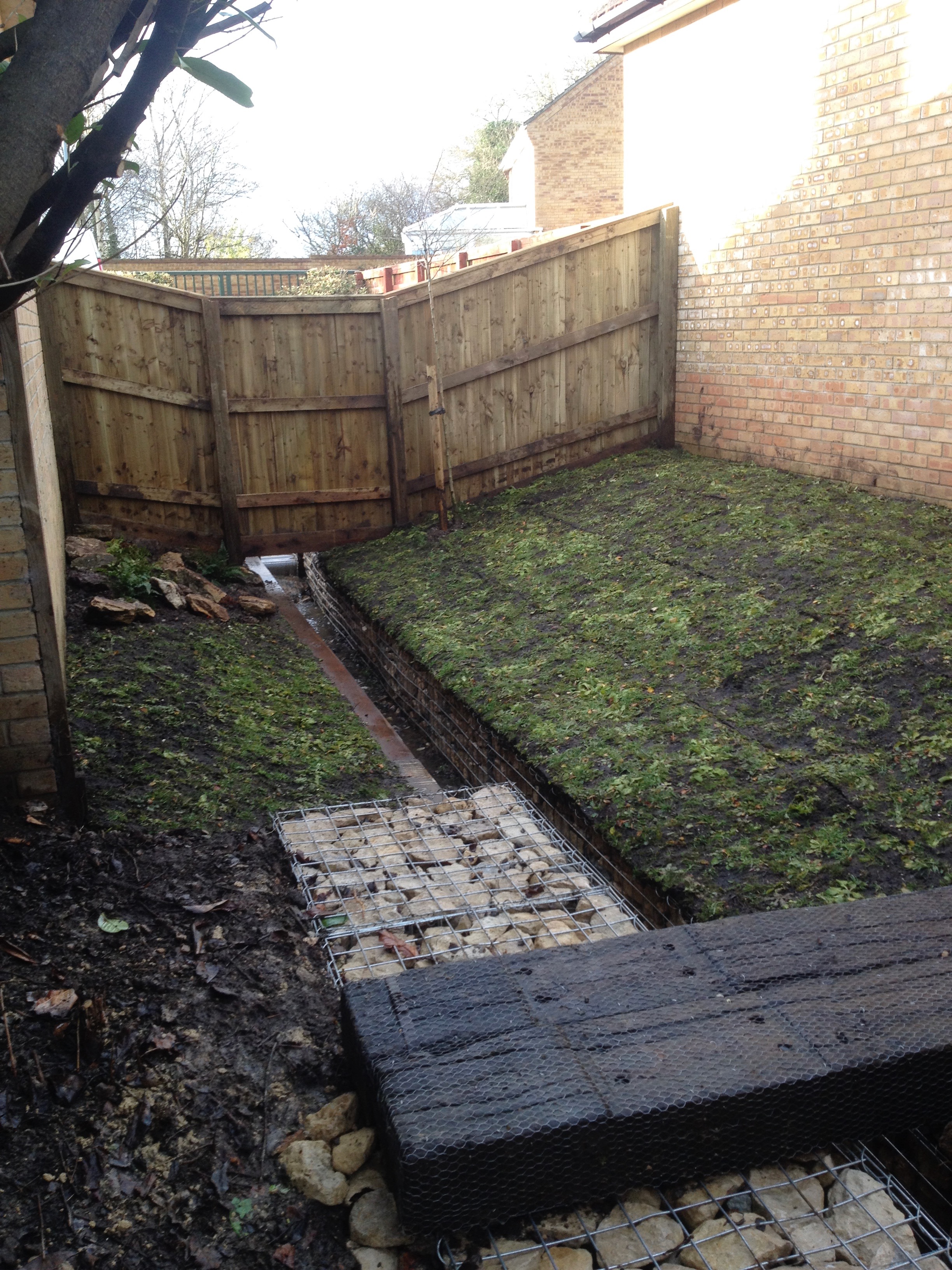 On the other side of the (now replaced) fence we installed a bridge using a reclaimed railway sleepers and a wildflower turf bank