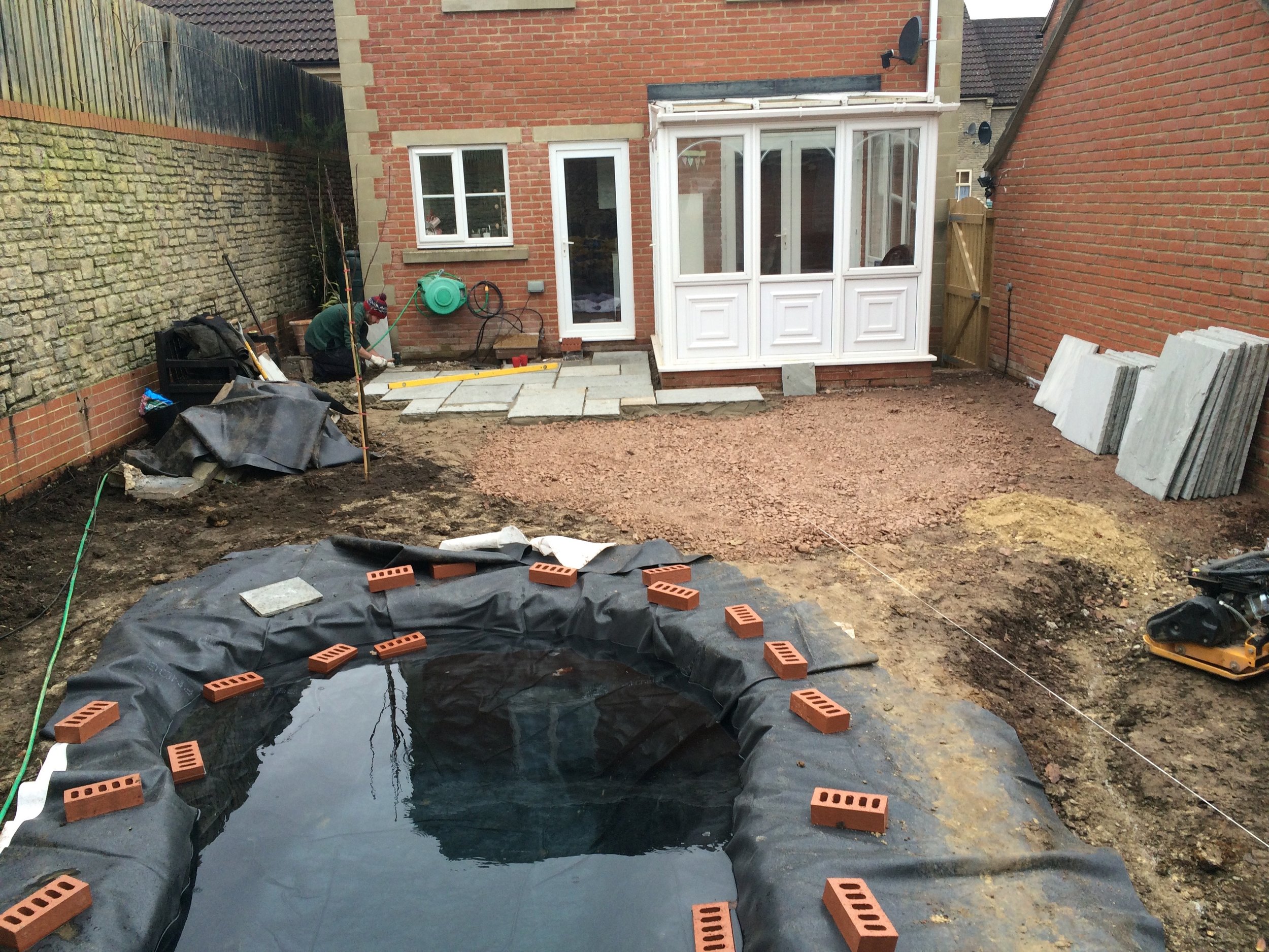 The main pond is dug and the liner weighted down whilst it fills.