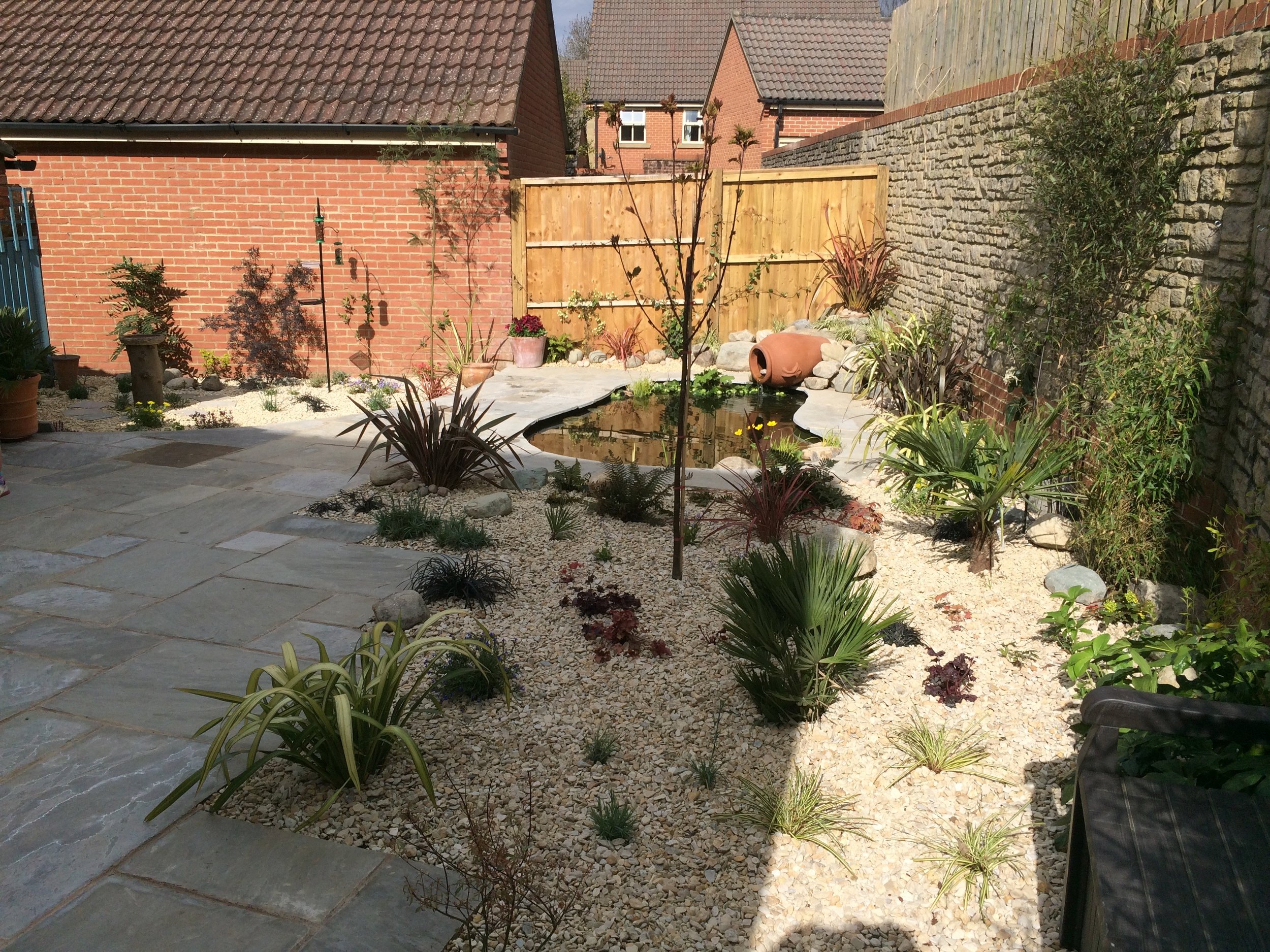 The completed garden. The pond sits beautifully within the planting. The grey sandstone contrasts well with the buff gravel and both sit back to allow the plants to do the talking.