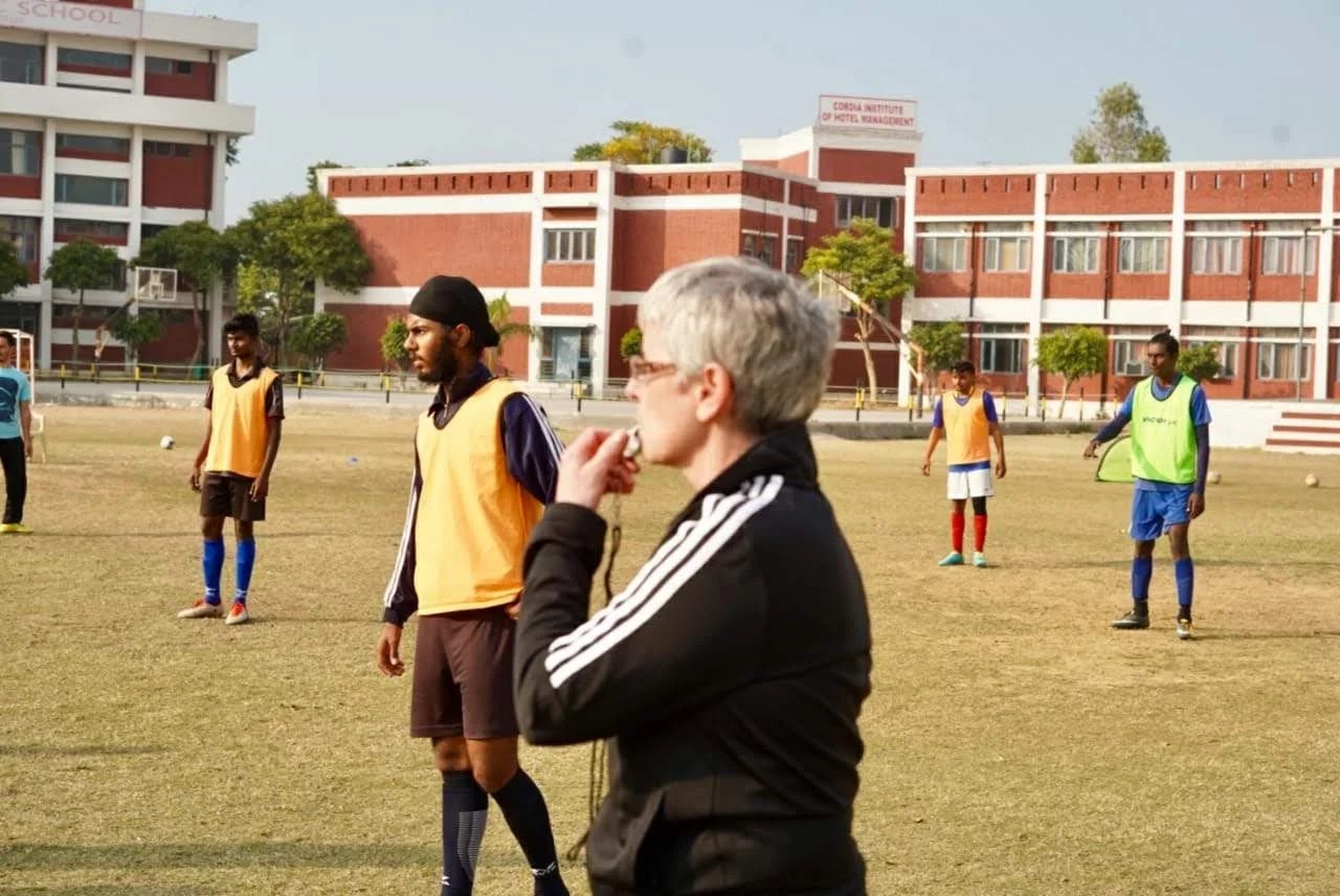 Julie teaching young girls football