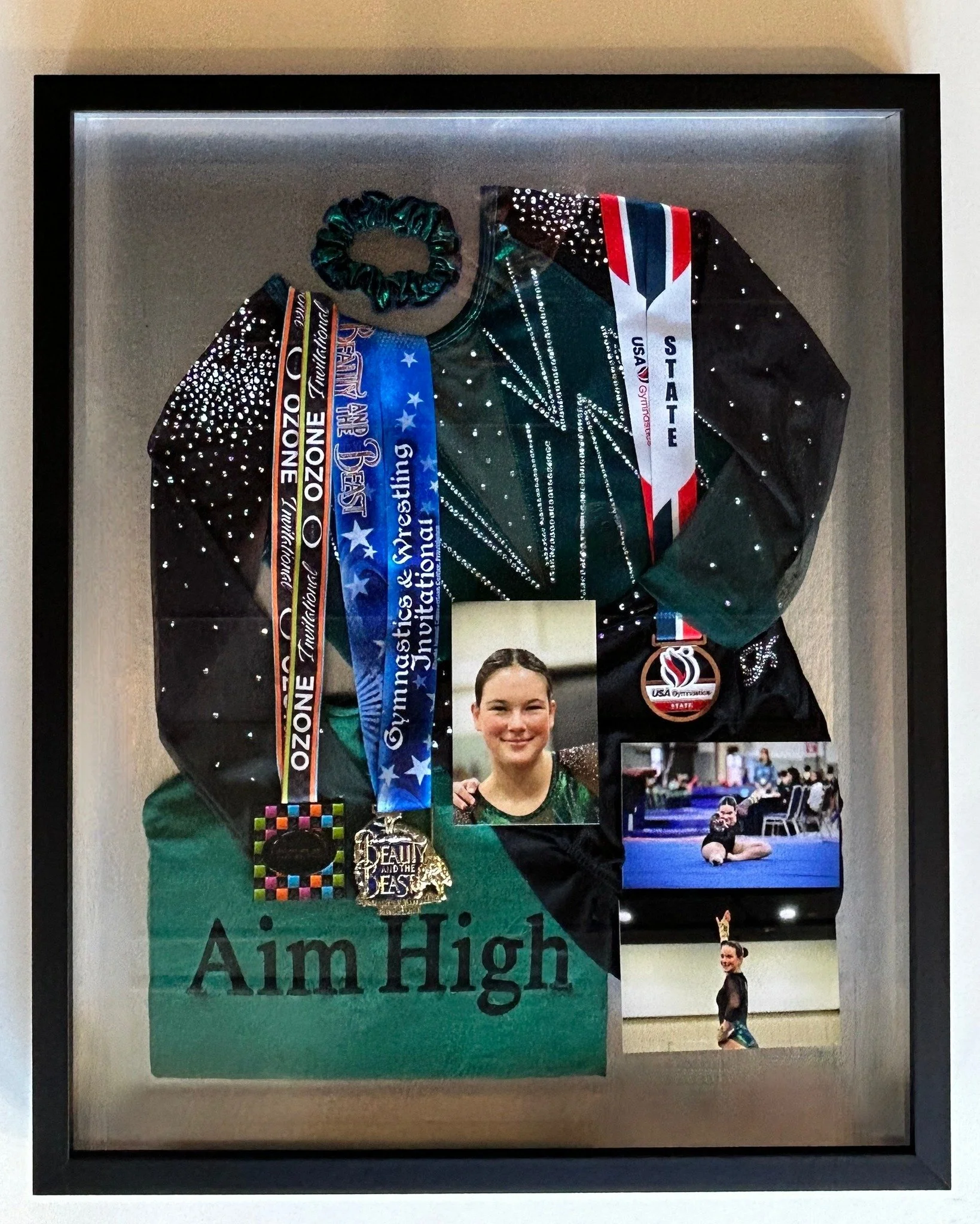 This gymnastics theme shadow box is a great example of the many techniques we can come up with to preserve the things that are precious to you! We custom build a box using frames deep enough to store 3D items, perfectly measured for your specific nee
