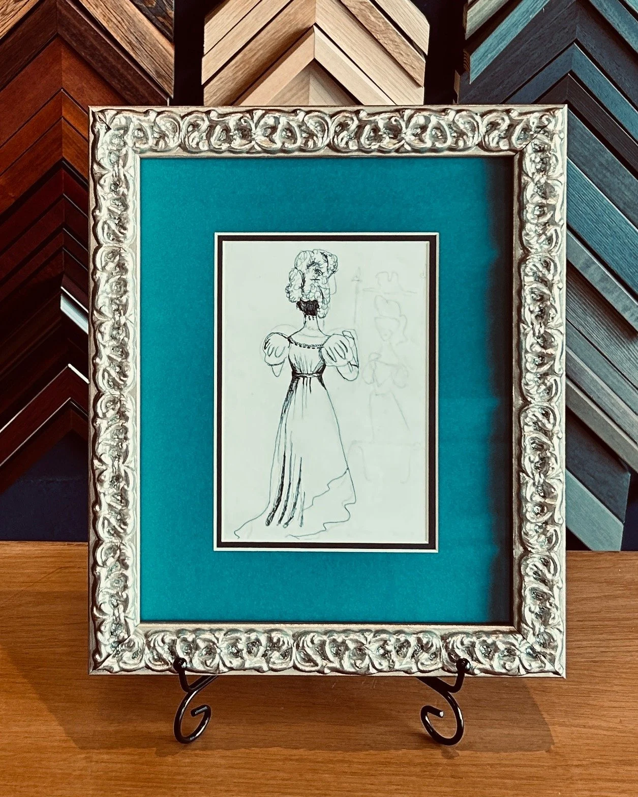 This drawing was done by our customers daughter, and what a great way to show appreciation for a thoughtful gift. This frame brings out the texture of the ruffles in the hat and dress, and teal mat adds a beautiful pop of color!

@wakefieldvillageass