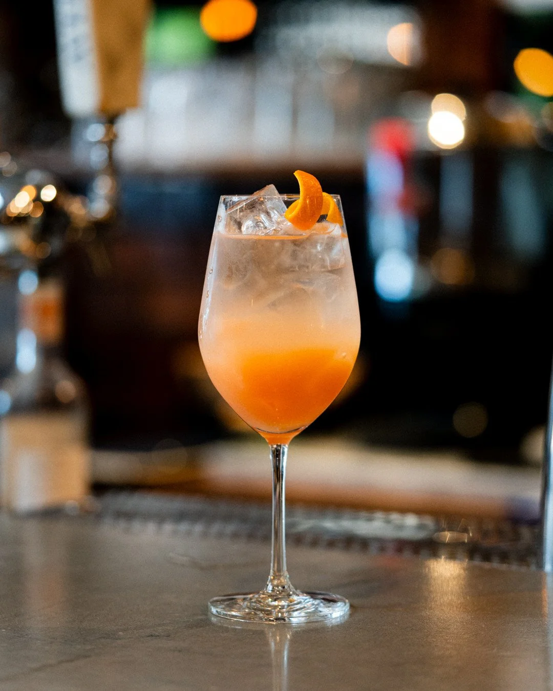 Aperol Spritz Au Comptoir | Aperol, splash of Lillet, soda, sparkling wine⁠
⁠
The spritz has roots going back to the 1800s when Austro-Hungarians in Venice found Italian wine too strong and added a splash of soda to dilute it.⁠
⁠
By the 1950s, Aperol