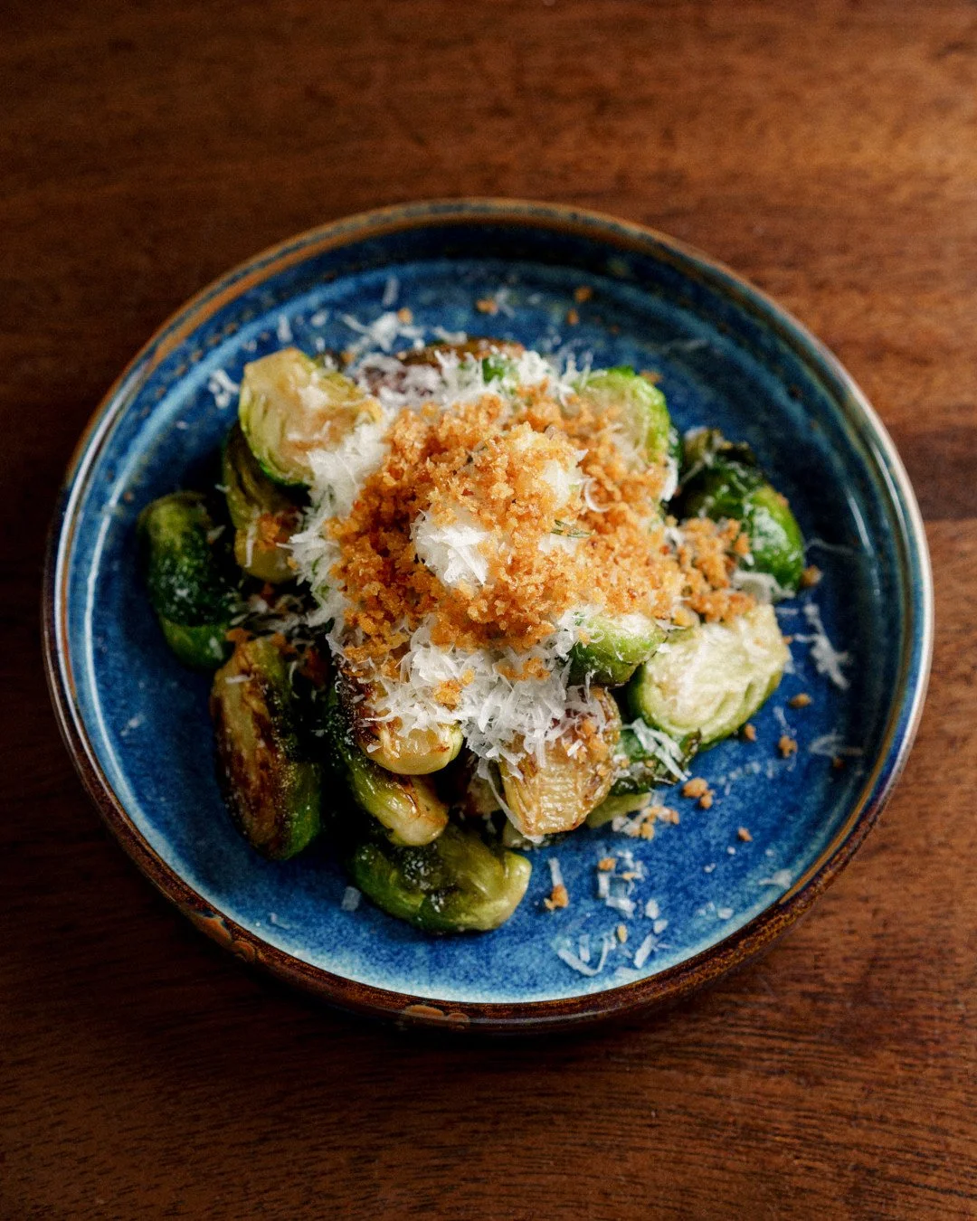 Brussels Sprouts | grana padano, chili crumb⁠
⁠
Brussels sprouts get a bad reputation from being overcooked and underseasoned. Ours are neither. Saut&eacute;ed until the edges are crispy and caramelized, tossed with grana padano for that nutty, salty