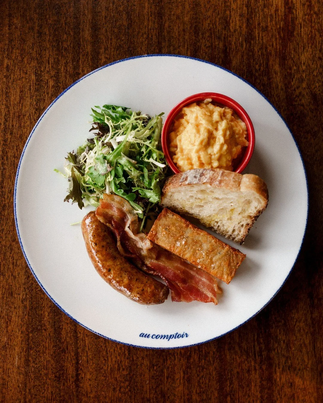 Assiette Au Comptoir | scrambled eggs, house-made sausage, bacon, country bread, duck fat and thyme potato r&ouml;sti⁠
⠀⁠
Our classic breakfast plate. The one people come back for because it covers everything you want in the morning.⁠
⠀⁠
Scrambled eg