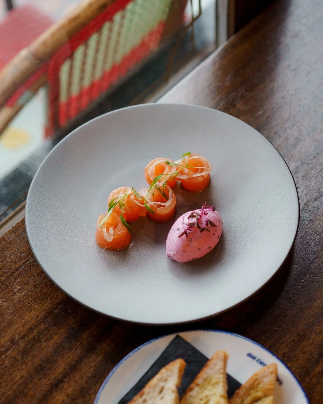 Gravlax de Saumon | cured salmon, beet cr&egrave;me fra&icirc;che, fine herbs, sourdough⁠
⠀⁠
Gravlax literally means &quot;buried salmon.&quot; Scandinavian fishermen in the 1300s would dig holes near the beach, bury salted fish in the sand, and let 