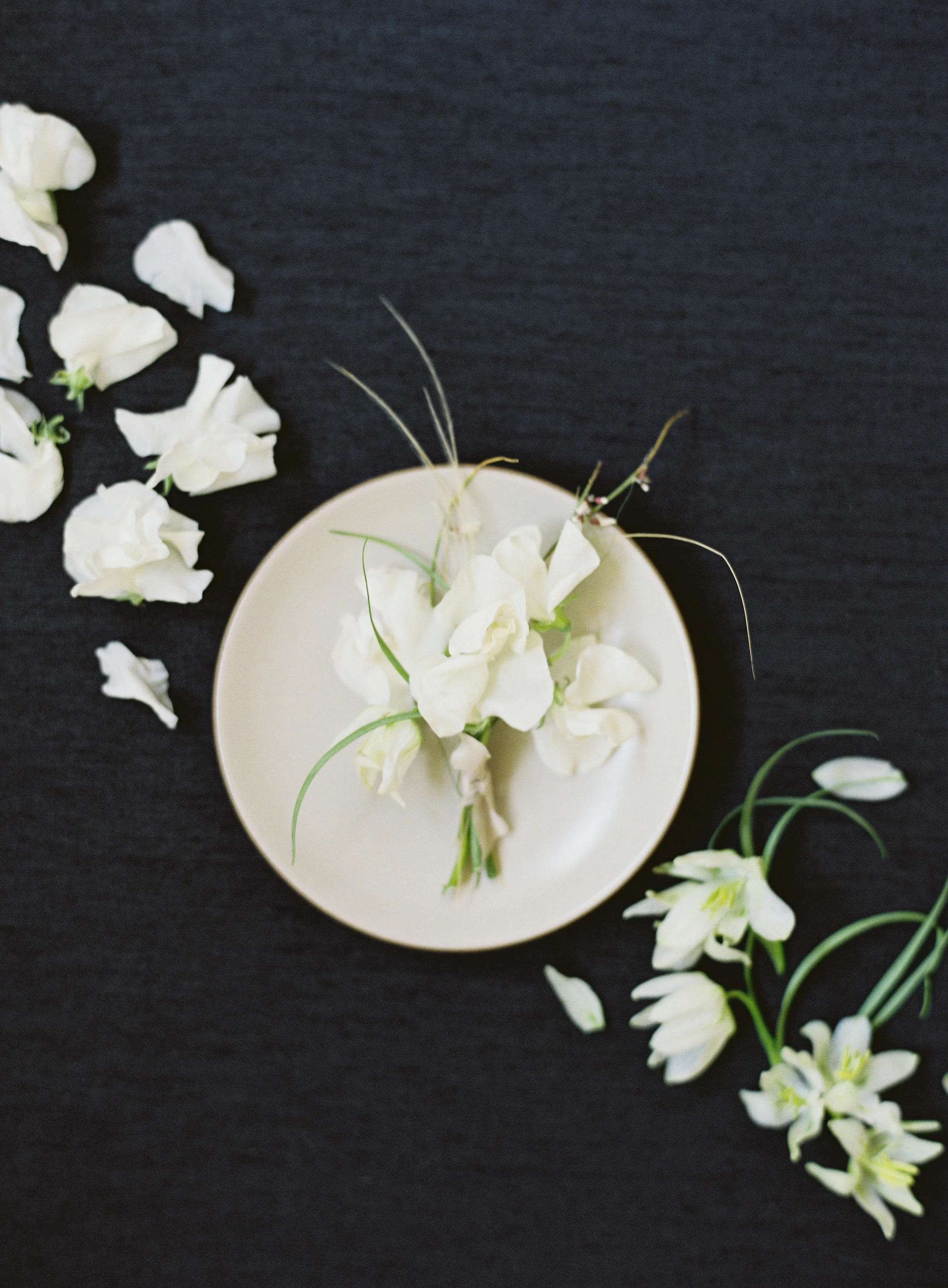 “I love creating contrast when selecting a backdrop color to use for photographing the floral details.” A bold black styling board is featured in this photo.