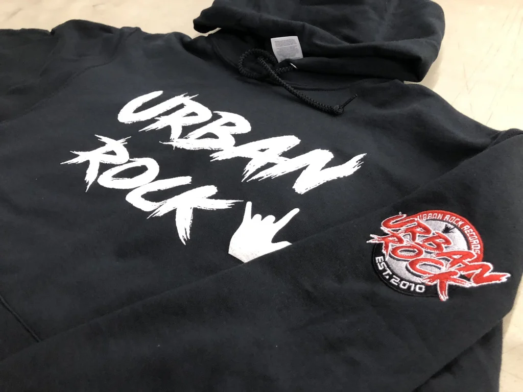 Utica, NY-based decorator A&P Master Images had a lot of ground to cover on this hoodie for Urban Rock Records, so the team screen printed a large “Urban Rock” text and graphics on the front and embroidered its 35,000-stitch logo on the sleeve. PRODUCT PICK: Check out our Gildan Heavy Blend Hooded Sweatshirt .