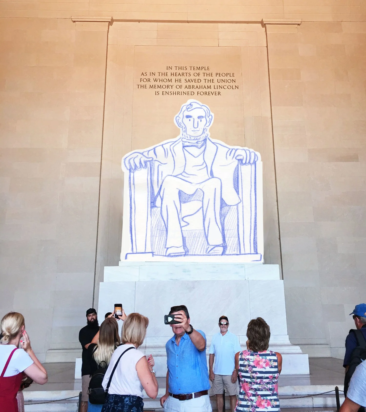 Visitors in front of the Lincoln Memorial in Washington, D.C., with a large outline drawing of Abraham Lincoln on the wall behind them