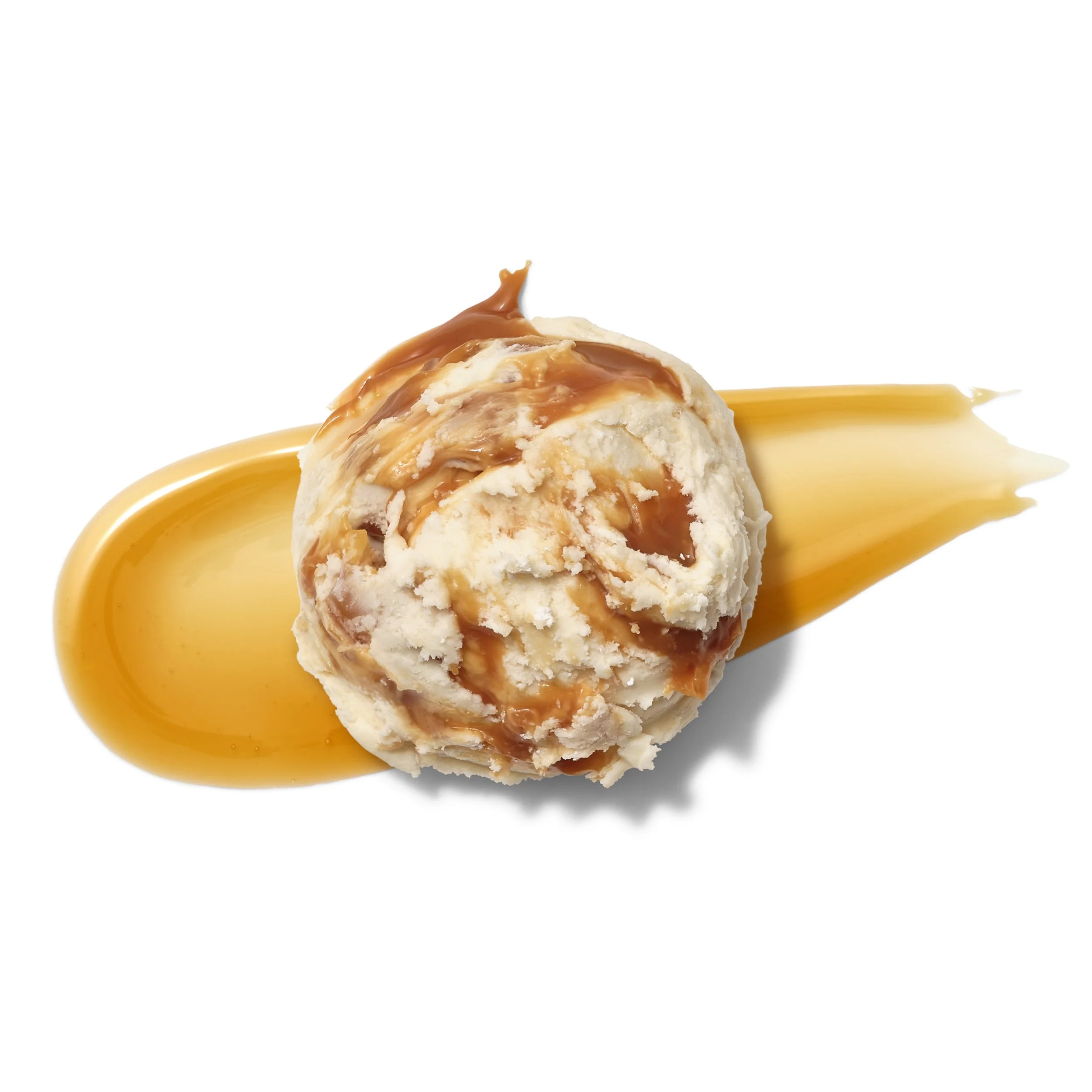 Scoops of vanilla ice cream topped with caramel sauce on a white background
